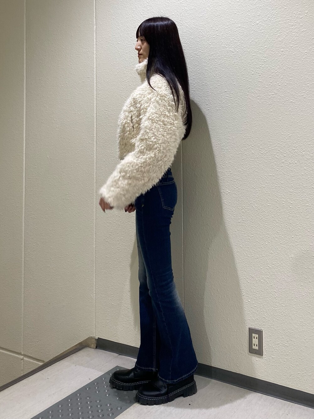 ブルー系のデニムパンツ、ホワイト系のブルゾンを着用したレディースの秋コーディネートの2枚目の写真