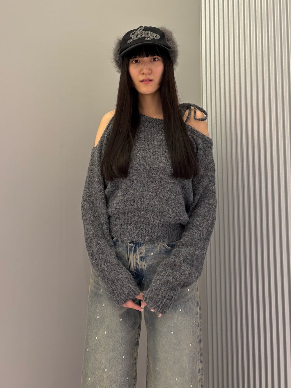 ブルー系のデニムパンツ、グレー系のニット/セーター、ブラック系のブーツを着用したレディースの冬コーディネートの6枚目の写真