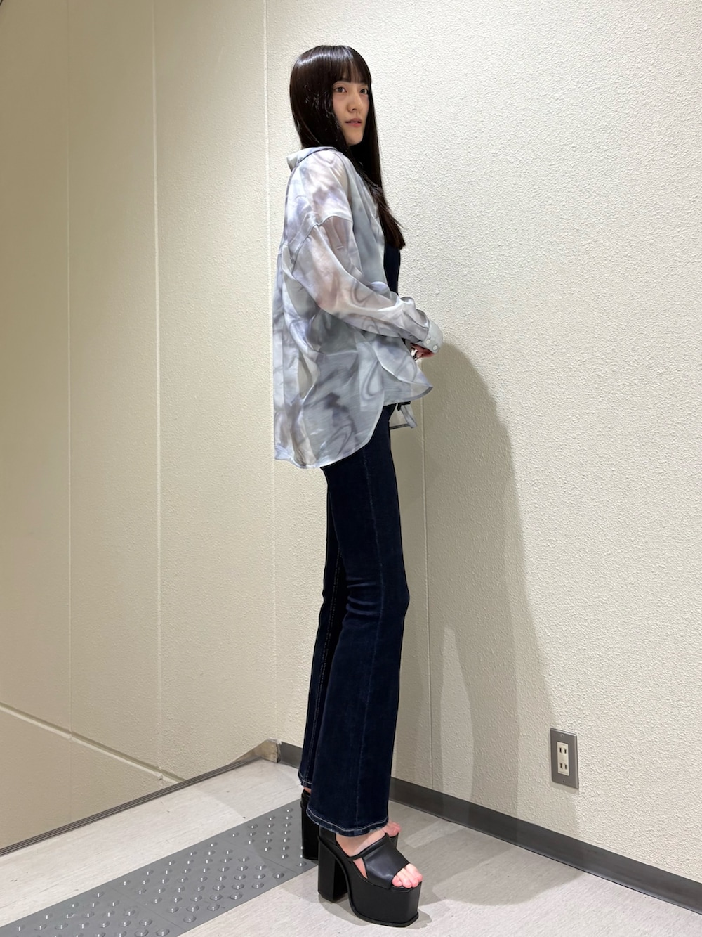 ブルー系のサロペット/オーバーオール、グレー系のシャツ/ブラウス、ブラック系のサンダルを着用したレディースの春コーディネートの3枚目の写真