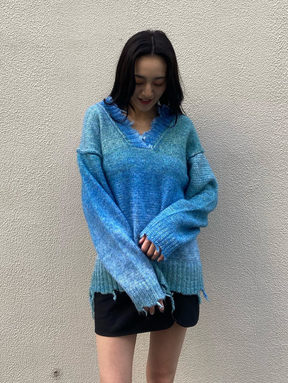 ブルー系のニット/セーター、ブラック系のブーツ、ホワイト系のダウンジャケット/コートを着用したレディースの冬コーディネートの7枚目の写真