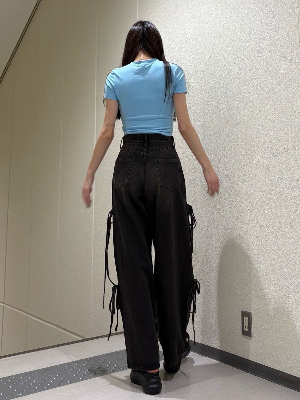 ブルー系のTシャツ/カットソー、ブラック系のデニムパンツ、ブラック系のサンダルを着用したレディースの春コーディネートの5枚目の写真