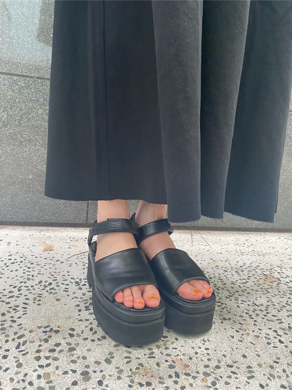 ブラック系のサンダル、ブラック系のワンピース、その他のハンドバッグを着用したレディースの夏コーディネートの6枚目の写真