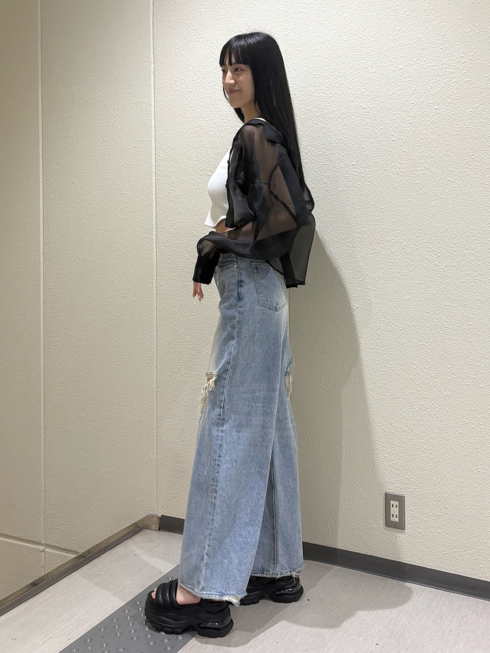 ホワイト系のニット/セーター、ブルー系のデニムパンツ、ブラック系のシャツ/ブラウスを着用したレディースの夏コーディネートの2枚目の写真