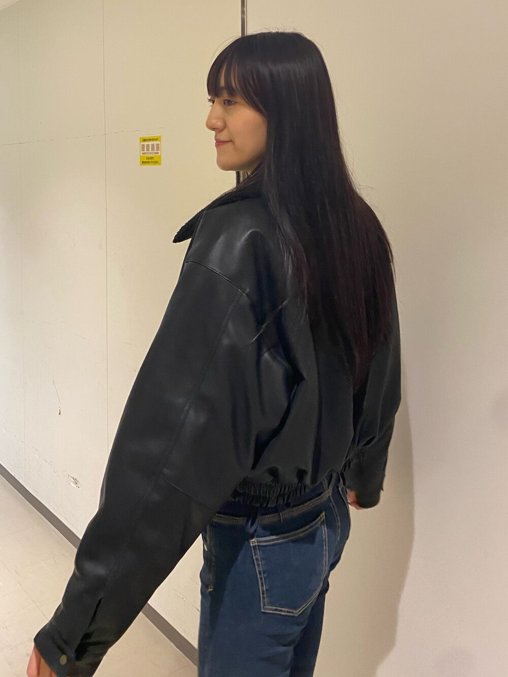 ブルー系のデニムパンツ、ホワイト系のニット/セーター、ブラック系のブルゾンを着用したレディースの秋コーディネートの5枚目の写真