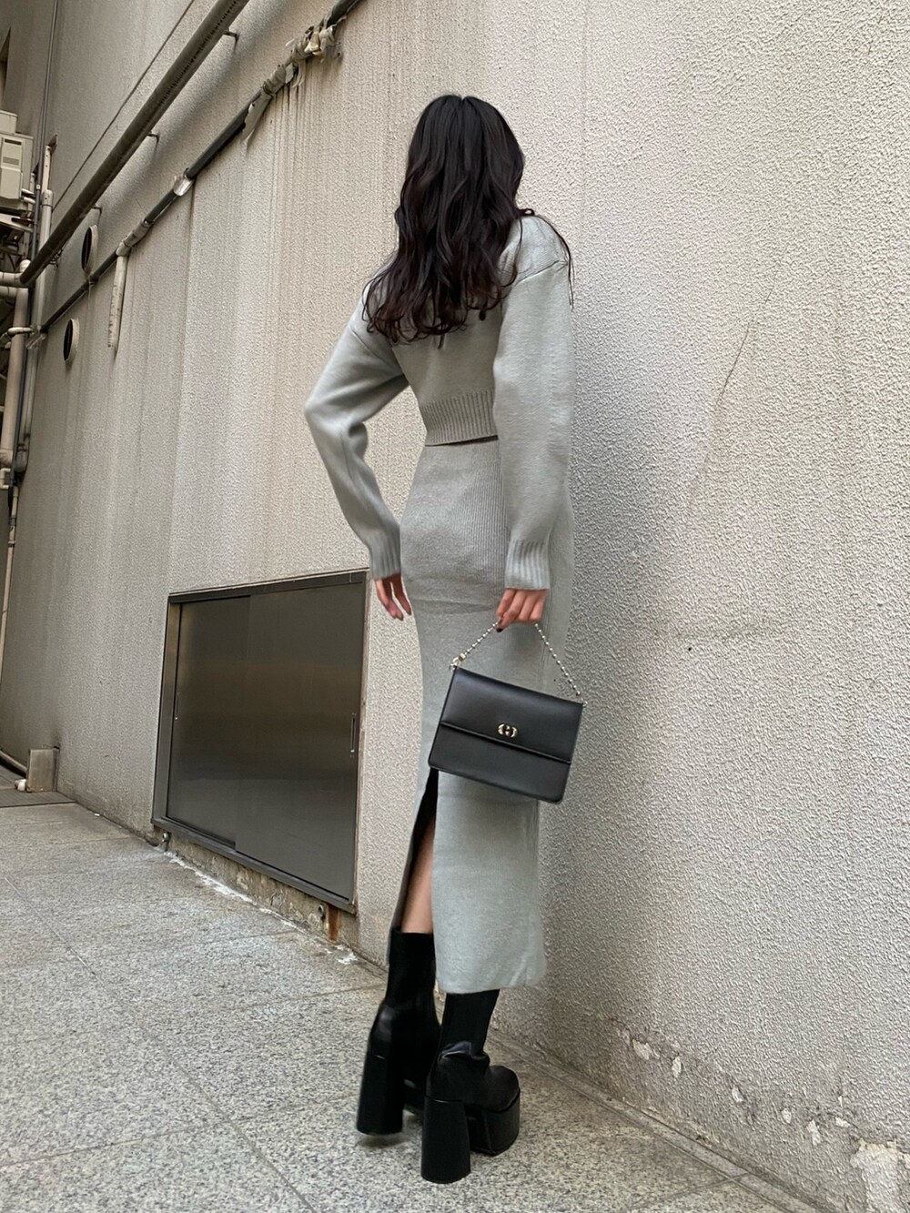 ブラック系のハンドバッグ、グレー系のスカート、グレー系のニット/セーターを着用したレディースの冬コーディネートの3枚目の写真