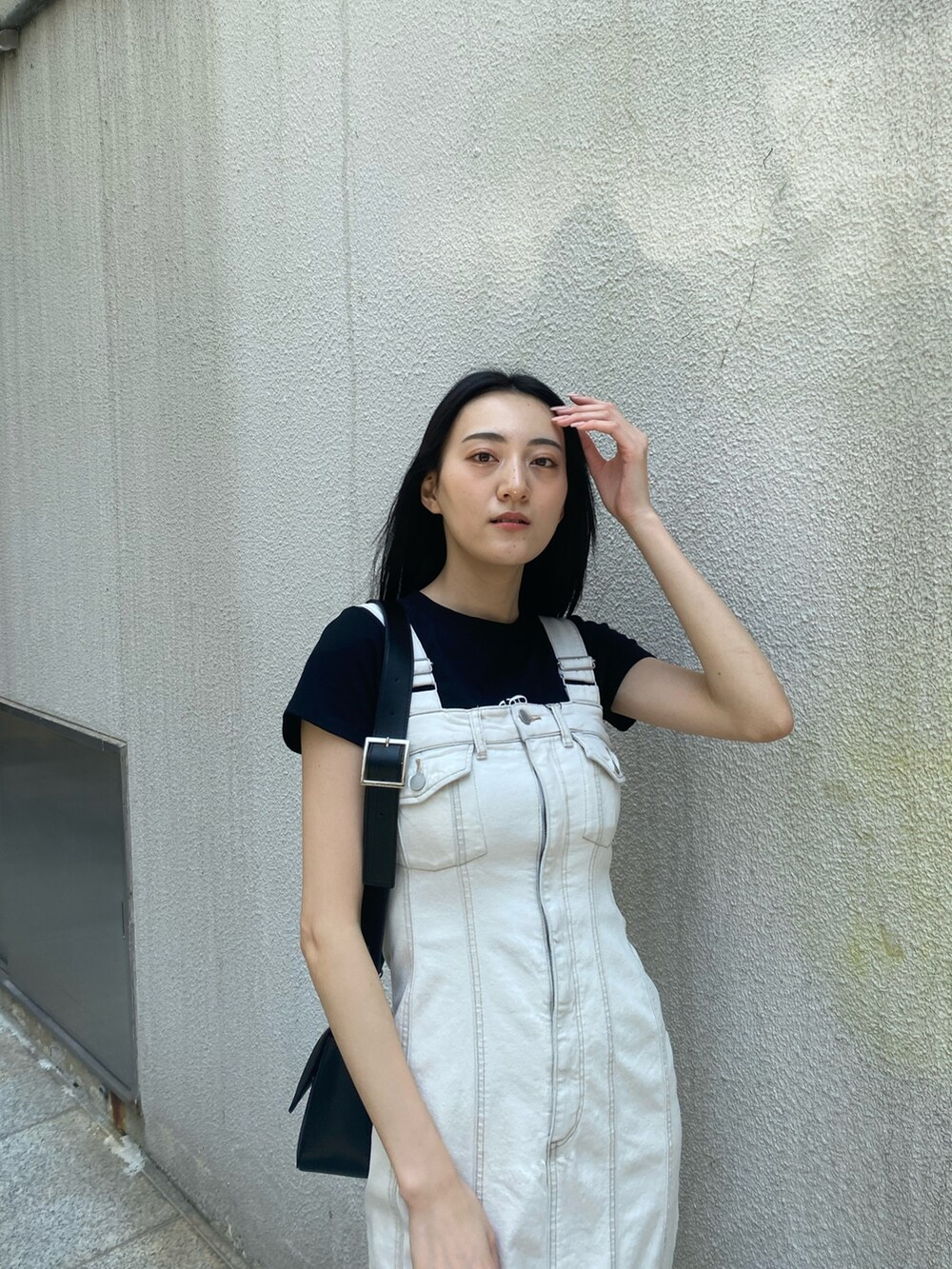 ブラック系のTシャツ/カットソー、ホワイト系のワンピース、ブラック系のショルダーバッグを着用したレディースの夏コーディネートの6枚目の写真