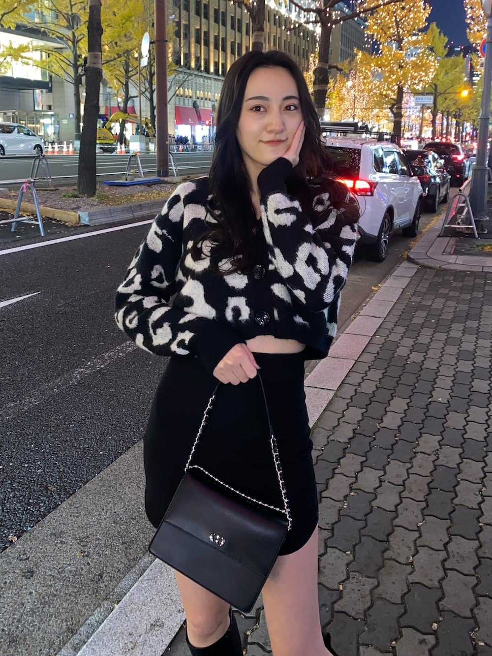 ブラック系のスカート、ブラック系のカーディガン/ボレロ、ブラック系のブーツを着用したレディースの冬コーディネートの5枚目の写真