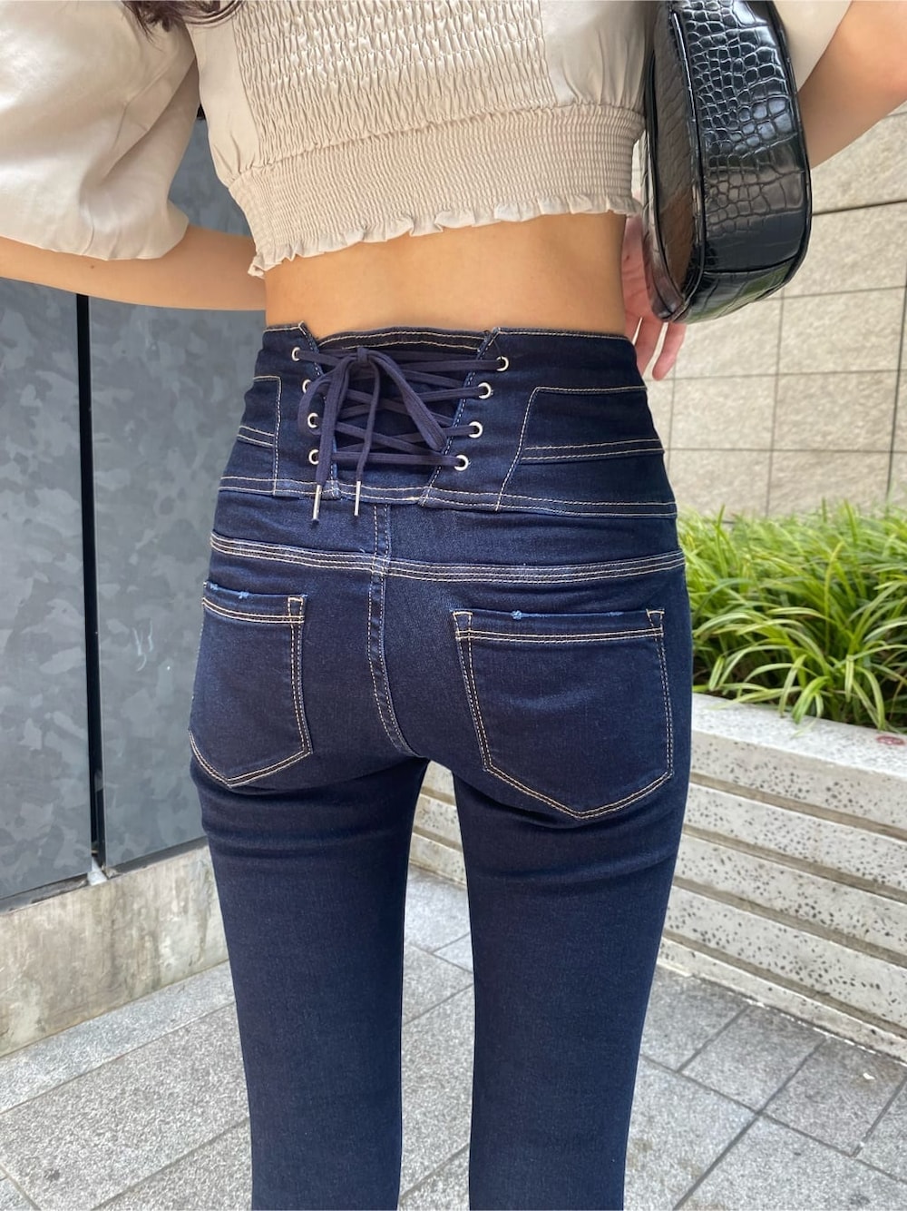 ブルー系のデニムパンツ、ホワイト系のTシャツ/カットソー、ブラック系のサンダルを着用したレディースの夏コーディネートの7枚目の写真