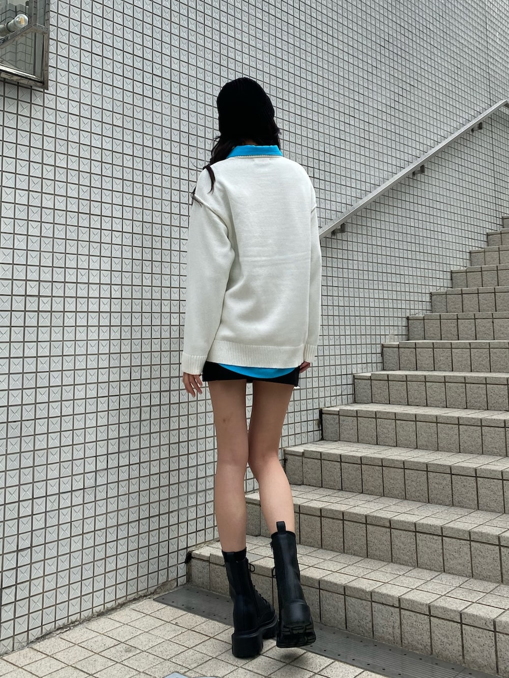 ブルー系のシャツ/ブラウス、ホワイト系のニット/セーター、ブラック系のスカートを着用したレディースの冬コーディネートの4枚目の写真