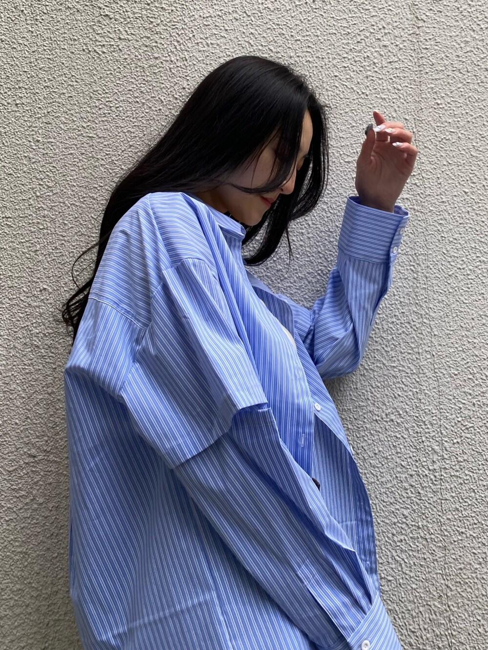 ブラック系のデニムパンツ、ブラック系のハンドバッグ、ブラック系のブーツを着用したレディースの春コーディネートの5枚目の写真