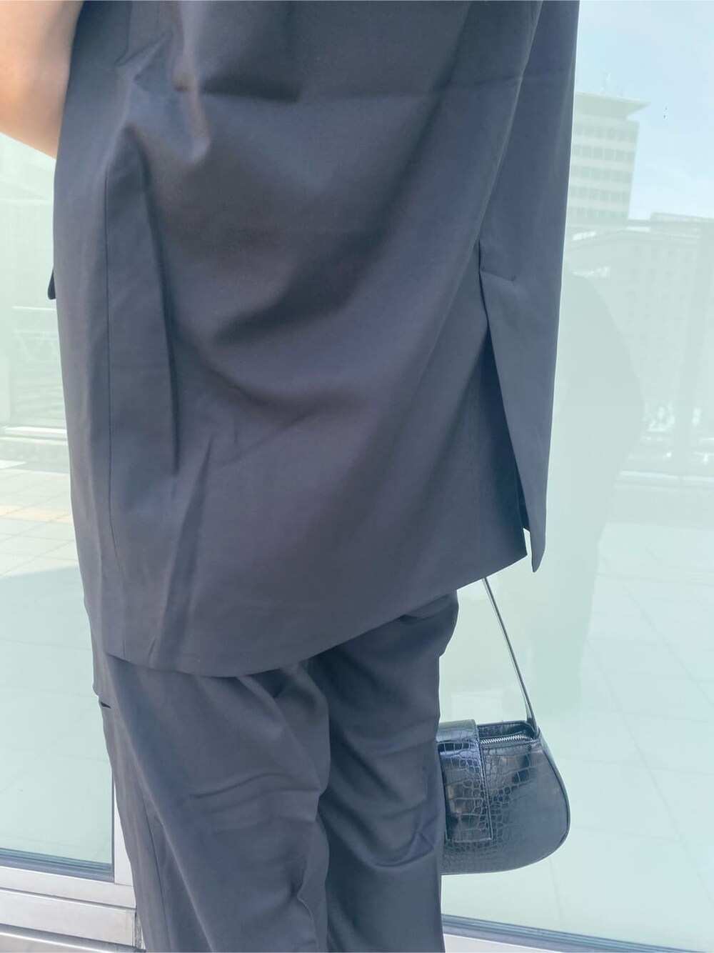 ホワイト系のスニーカー、ブラック系のベスト、ブラック系のその他パンツを着用したレディースの夏コーディネートの8枚目の写真