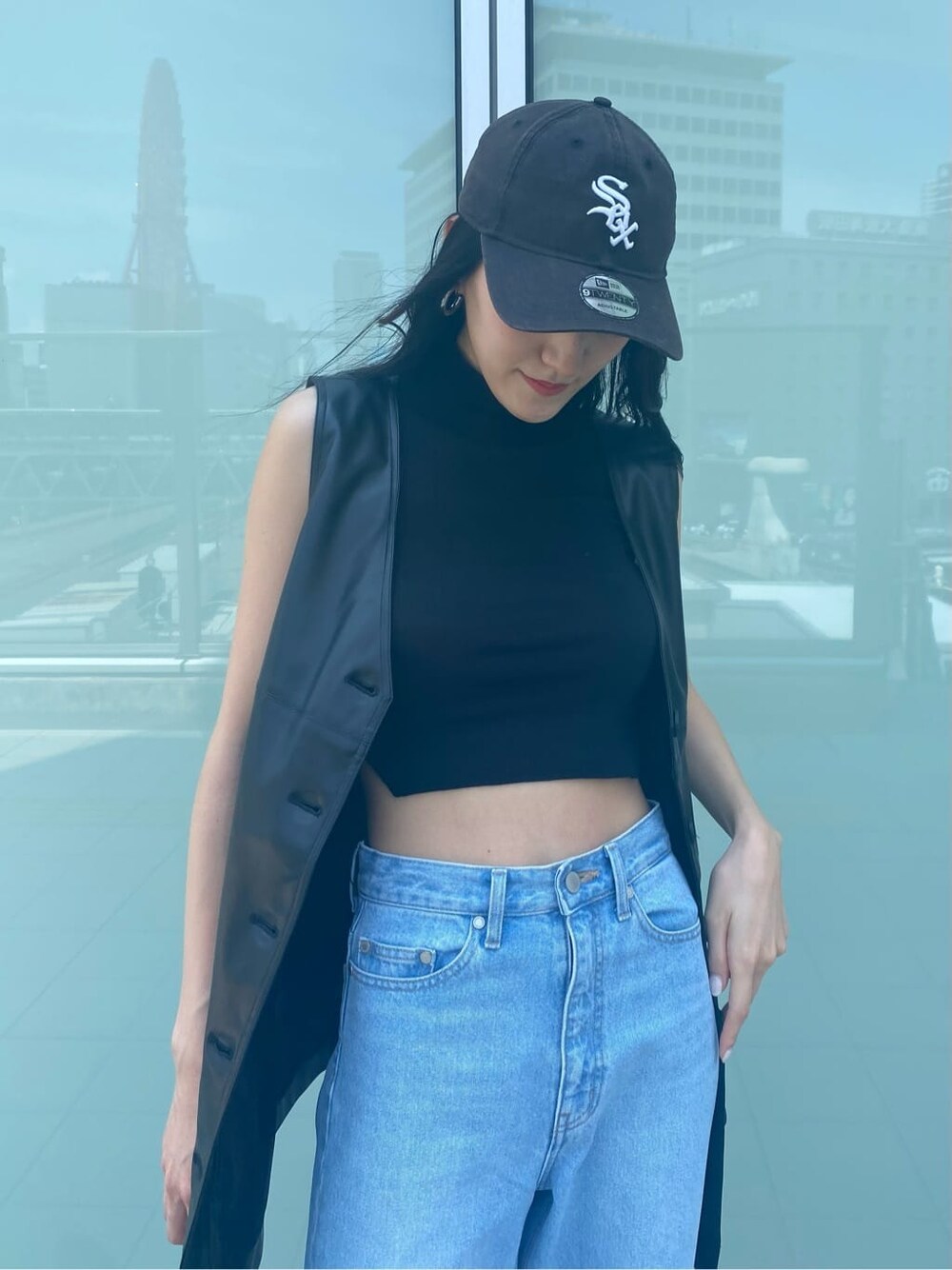 ブルー系のデニムパンツ、ブラック系のワンピース、ベージュ系のスリッポンを着用したレディースの夏コーディネートの5枚目の写真