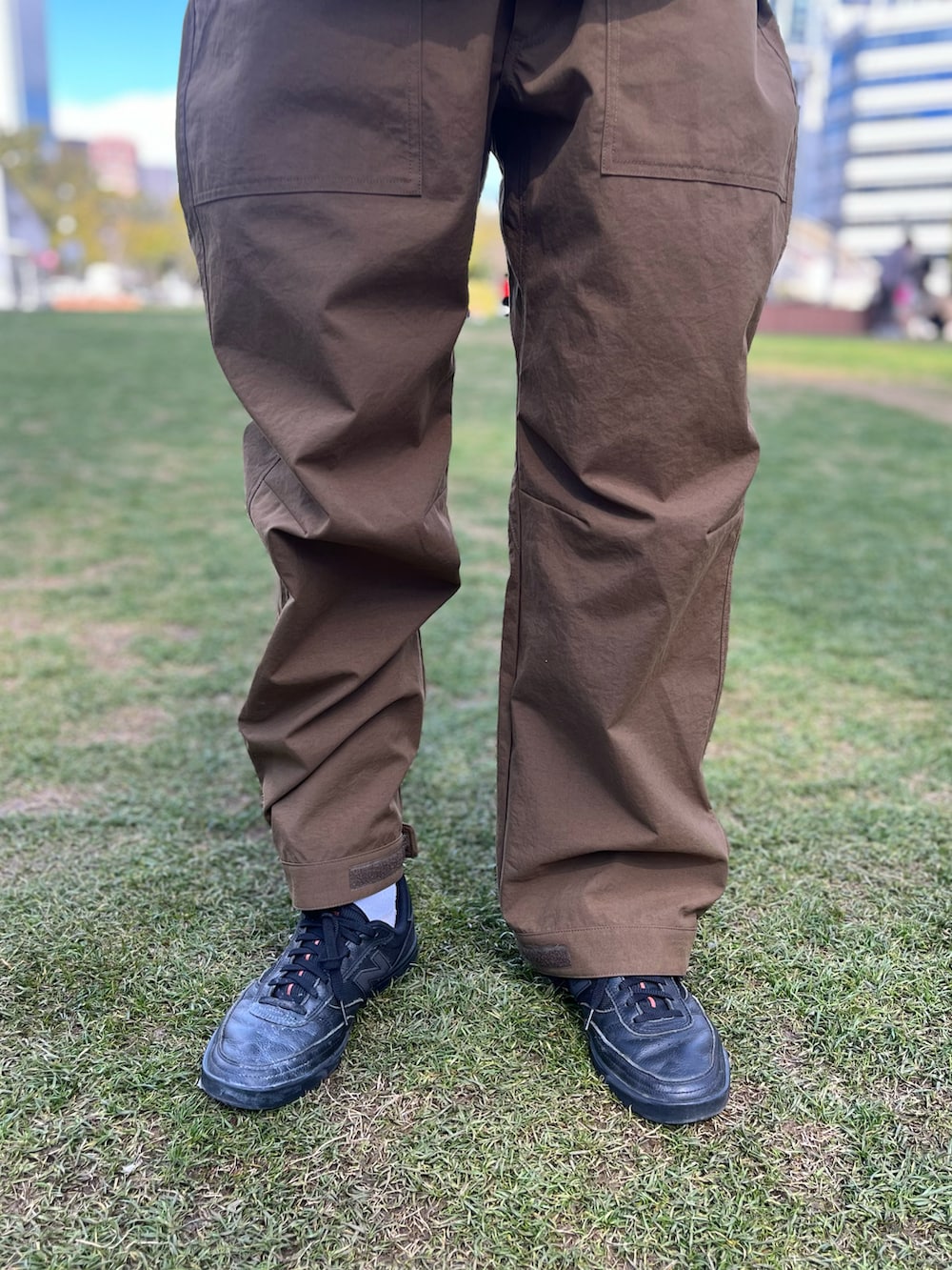 ブラック系のスニーカー、ブラウン系のその他パンツを着用したメンズの春コーディネートの3枚目の写真