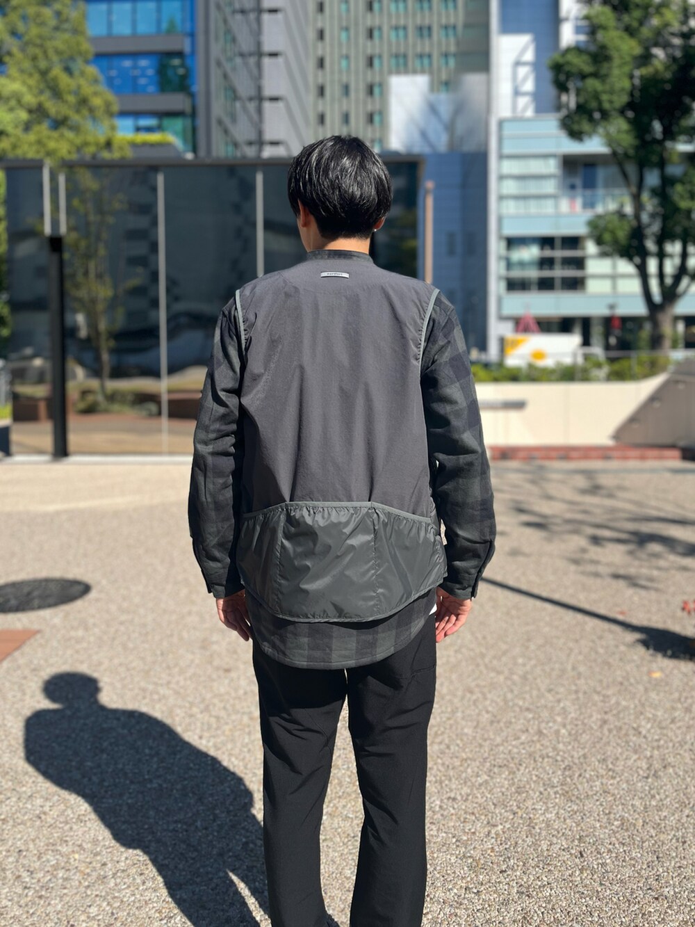 ブラック系のスラックス、グレー系のシャツ/ブラウス、グレー系のダウンベストを着用したメンズの秋コーディネートの2枚目の写真