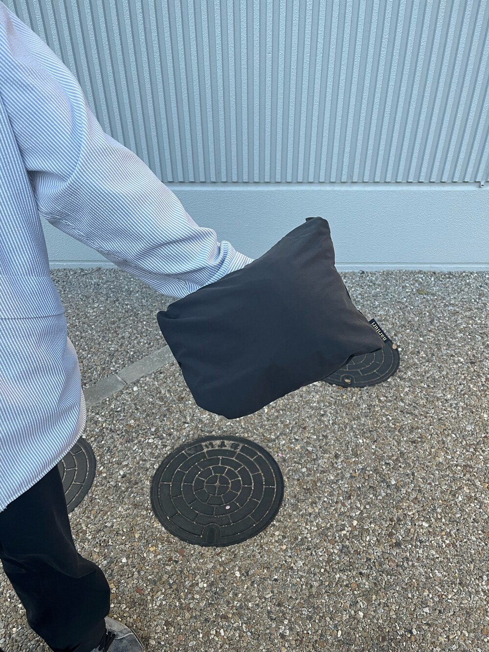 グレー系のシャツ/ブラウス、ブラック系のナイロンジャケット、ブラック系のキャップを着用したメンズの春コーディネートの3枚目の写真