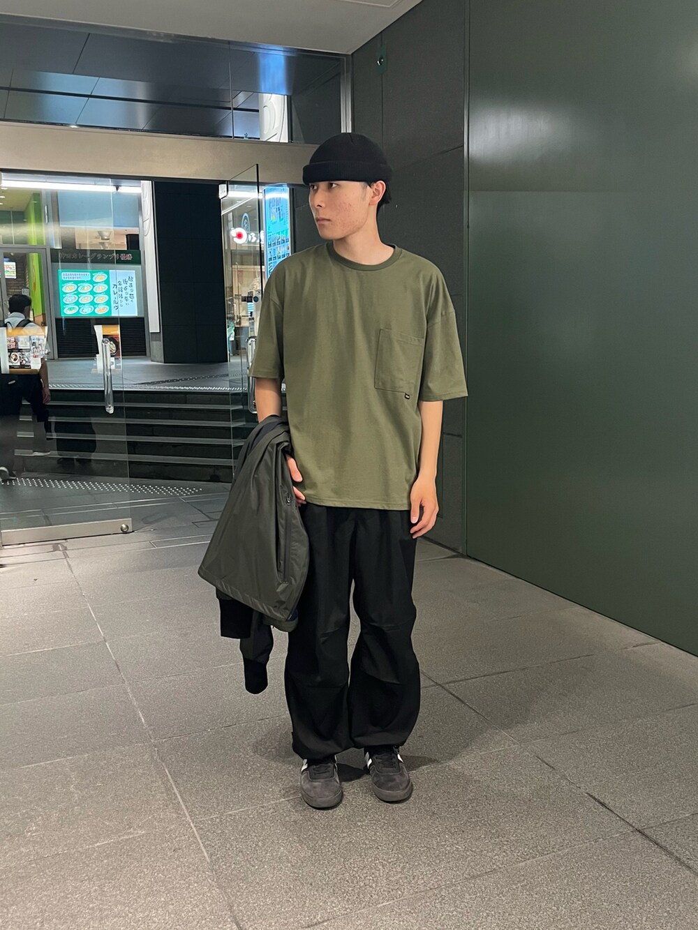 グリーン系のナイロンジャケット、グリーン系のTシャツ/カットソーを着用したメンズの夏コーディネートの2枚目の写真