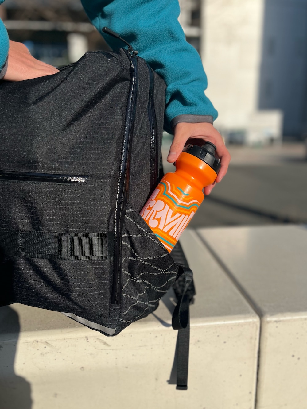 グレー系のパーカー、ブルー系のブルゾン、ブラック系のバックパック/リュックを着用したメンズの春コーディネートの5枚目の写真