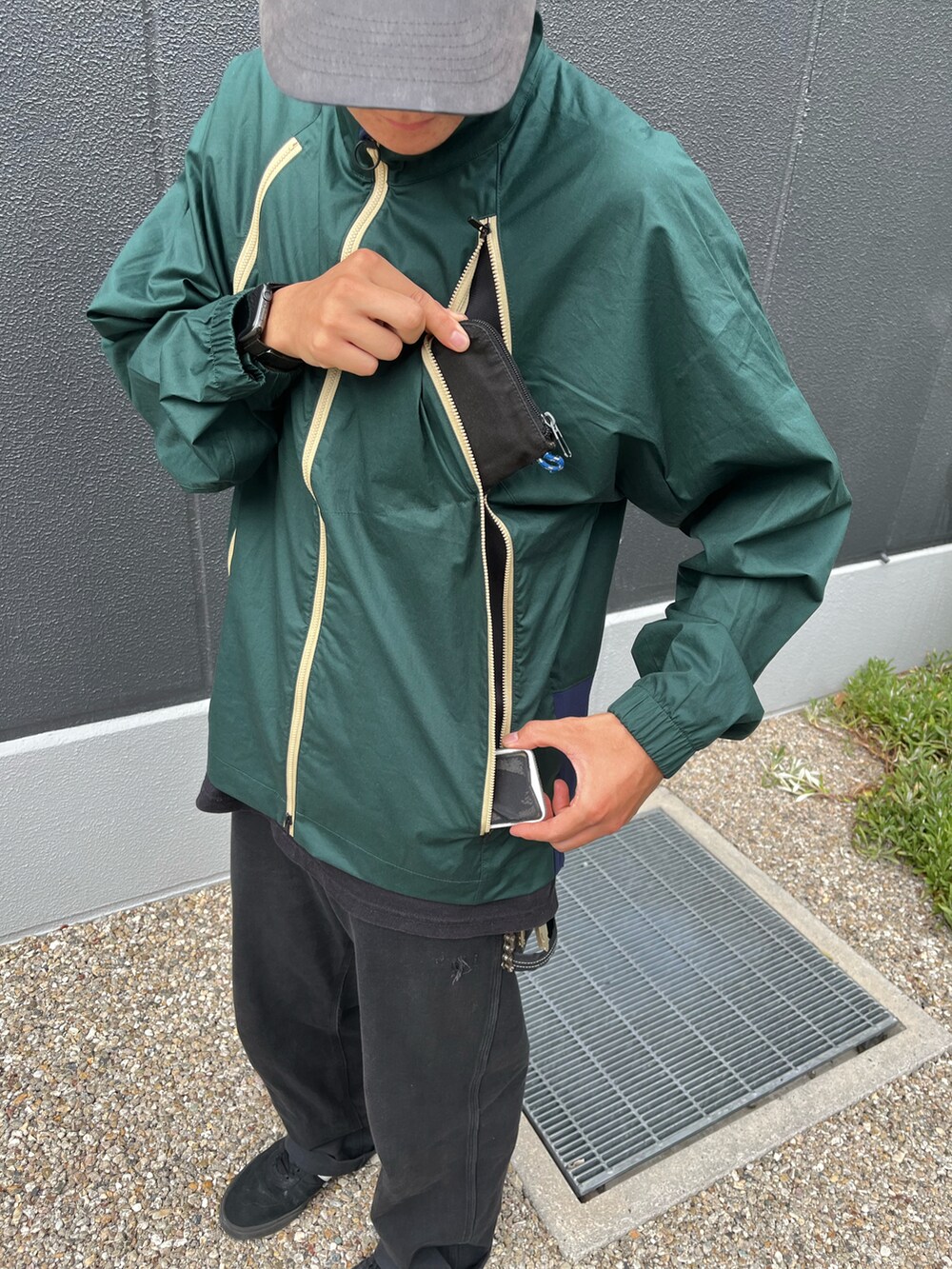 グリーン系のブルゾン、ブラック系のキャップを着用したメンズの秋コーディネートの3枚目の写真