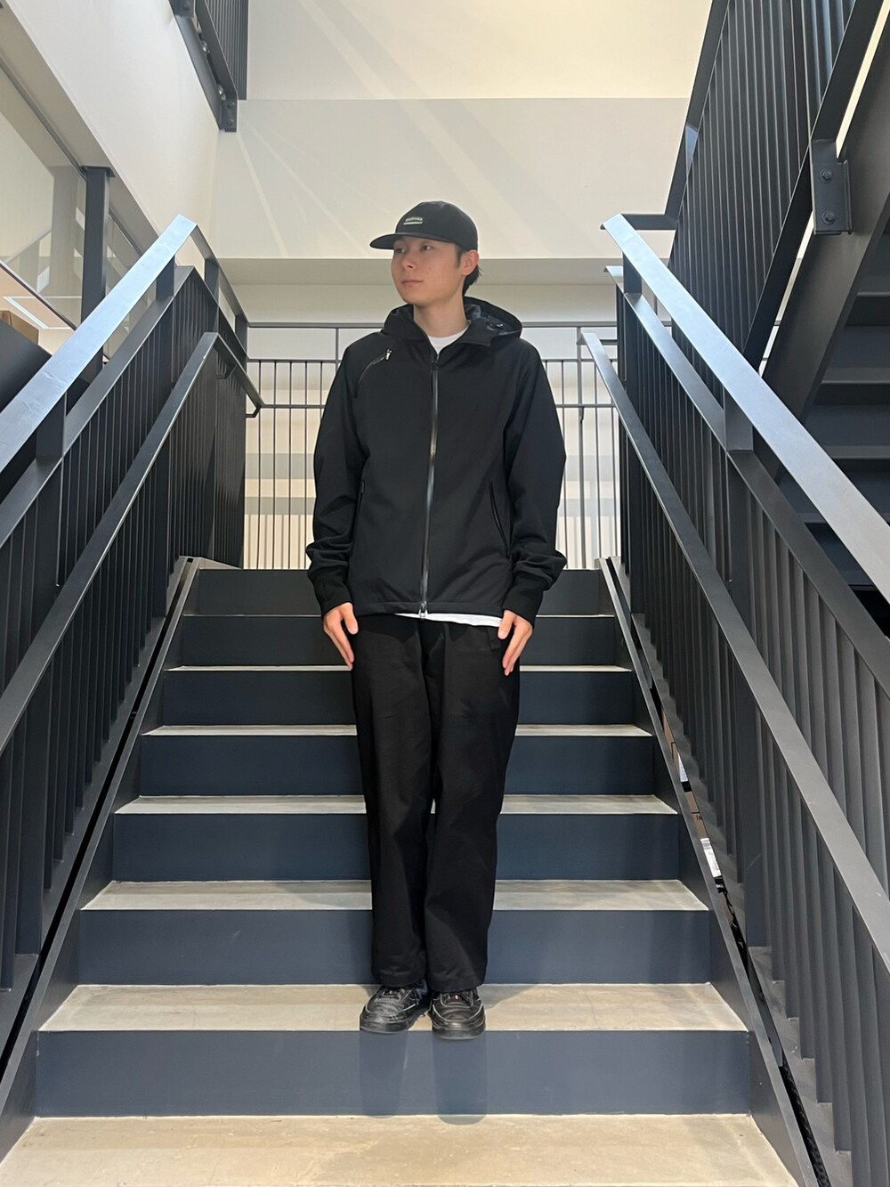ブラック系のマウンテンパーカー、ホワイト系のTシャツ/カットソーを着用したメンズの春コーディネートの2枚目の写真