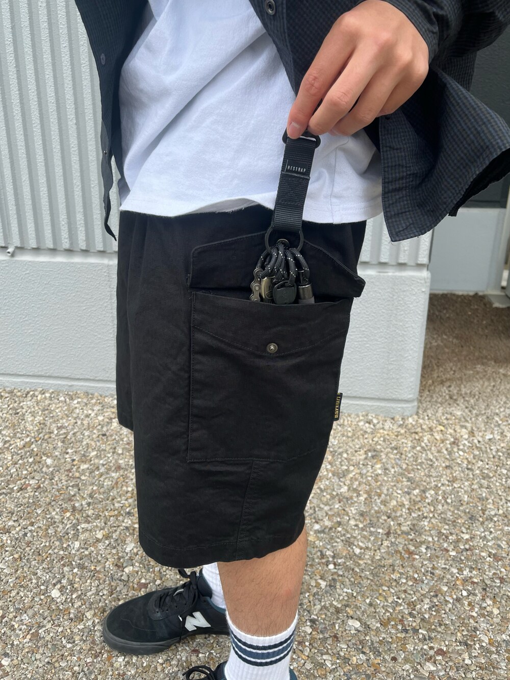 ブラック系のカーゴパンツ、ブルー系のシャツ/ブラウス、ブラック系のキャップを着用したメンズの春コーディネートの3枚目の写真