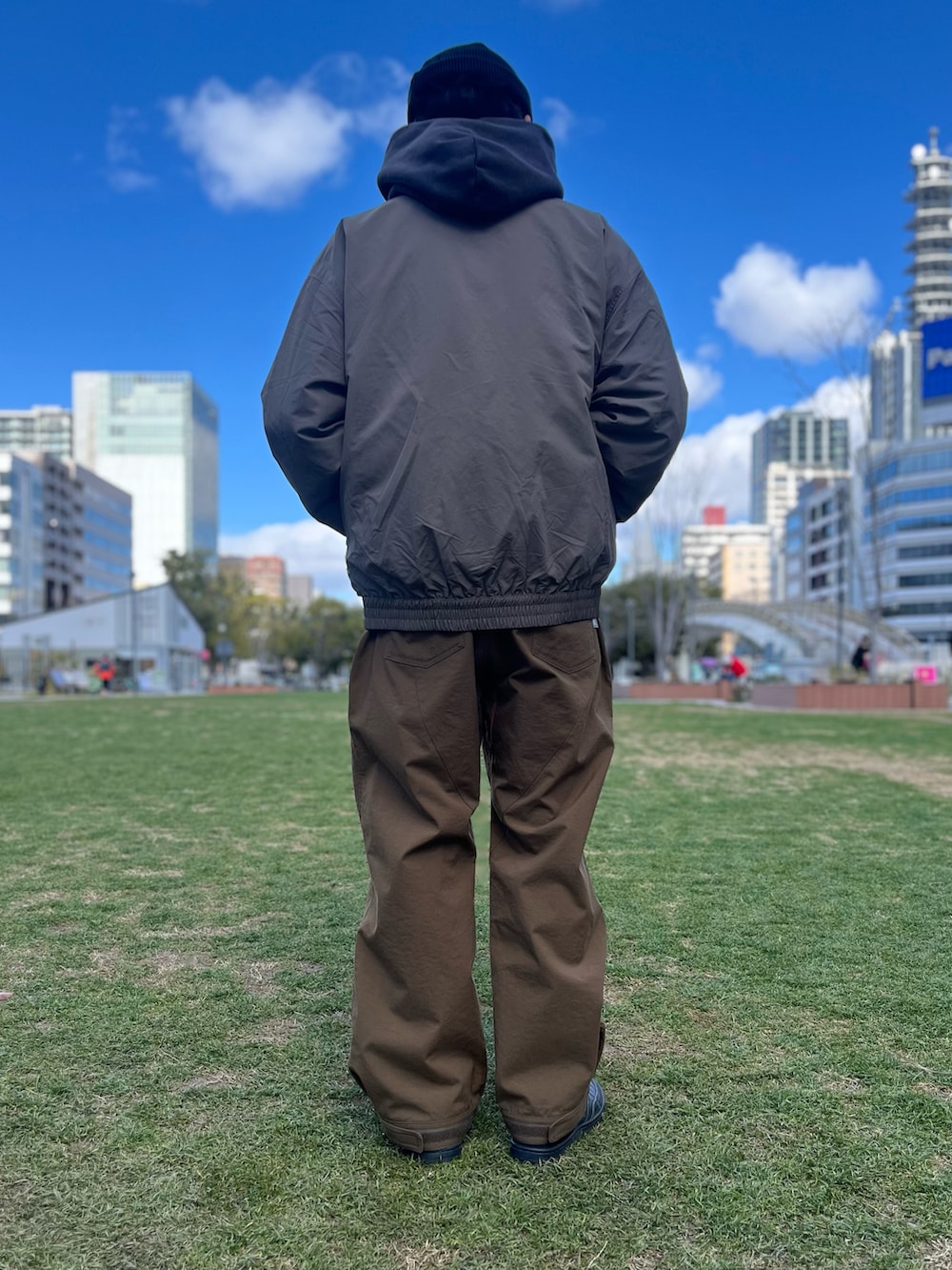 ブラック系のスニーカー、ブラウン系のその他パンツを着用したメンズの春コーディネートの2枚目の写真