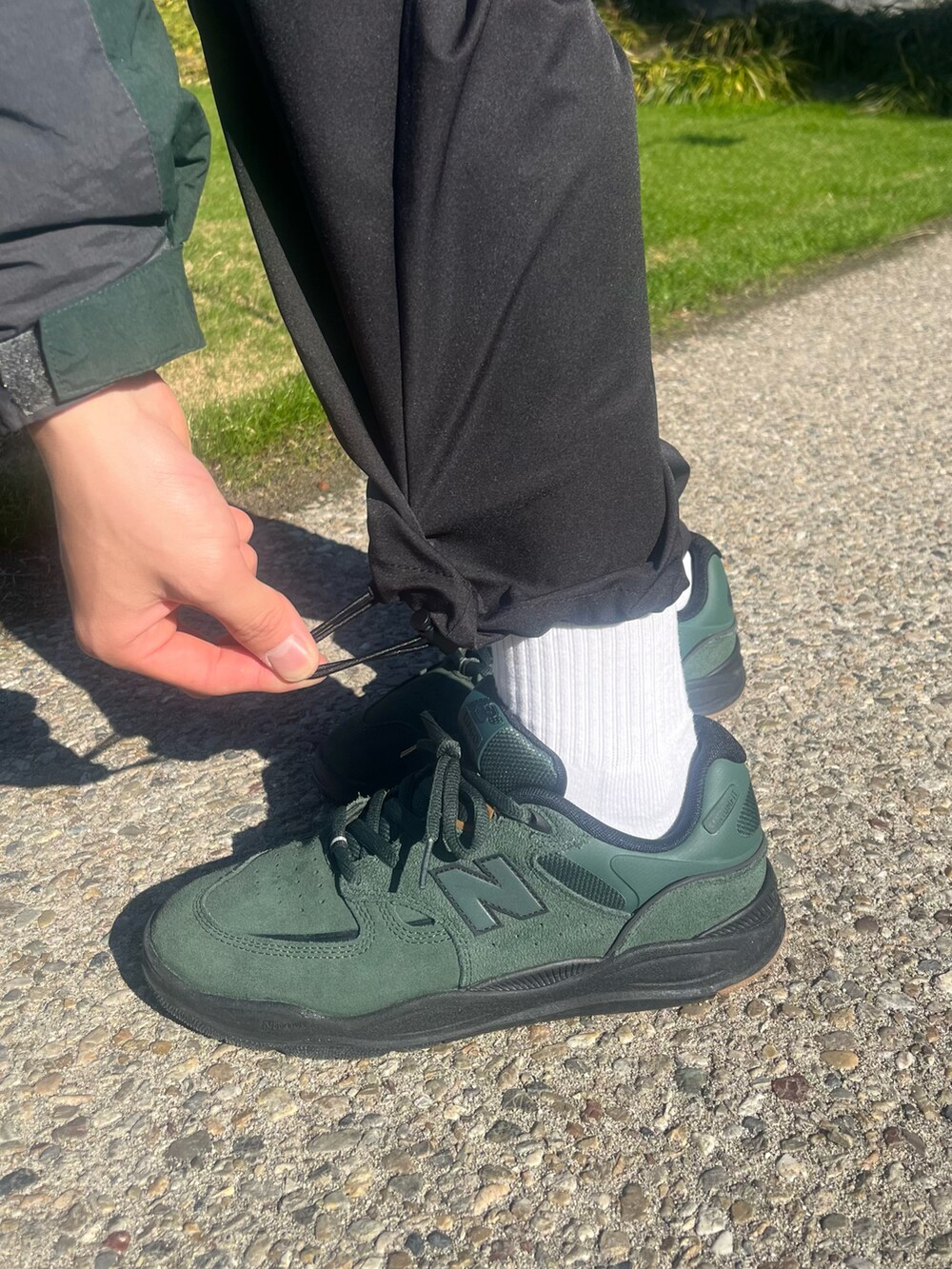 グリーン系のスニーカー、ブラック系のスウェットを着用したメンズの冬コーディネートの5枚目の写真