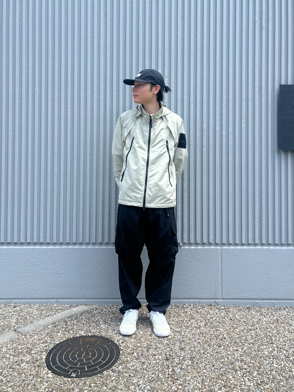 ブラック系のカーゴパンツ、ベージュ系のブルゾンを着用したメンズの春コーディネートの2枚目の写真