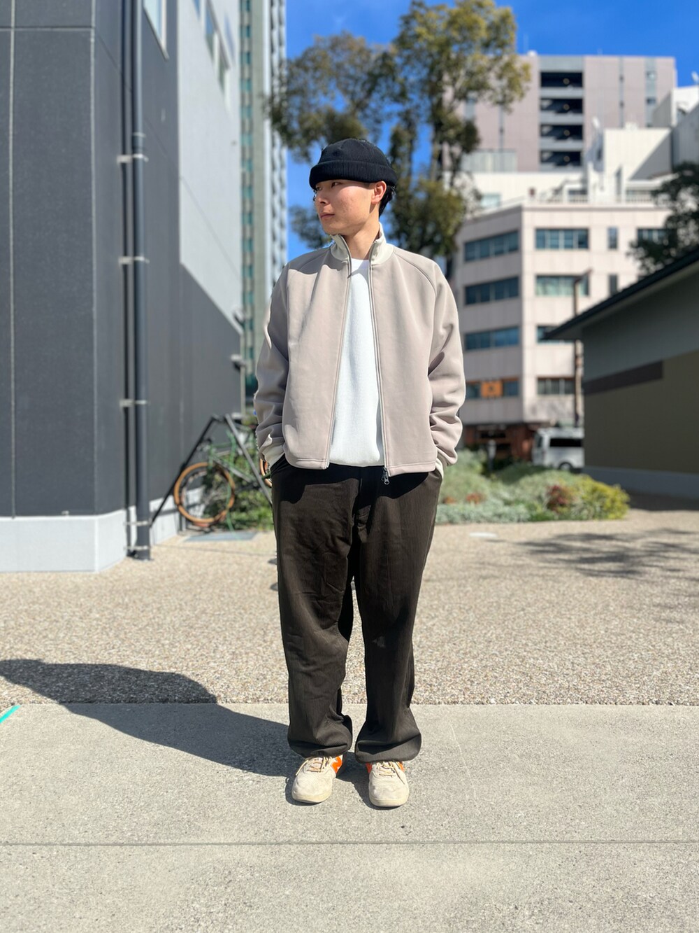 ベージュ系のブルゾン、ホワイト系のスウェット、ベージュ系のスニーカーを着用したメンズの春コーディネートの2枚目の写真