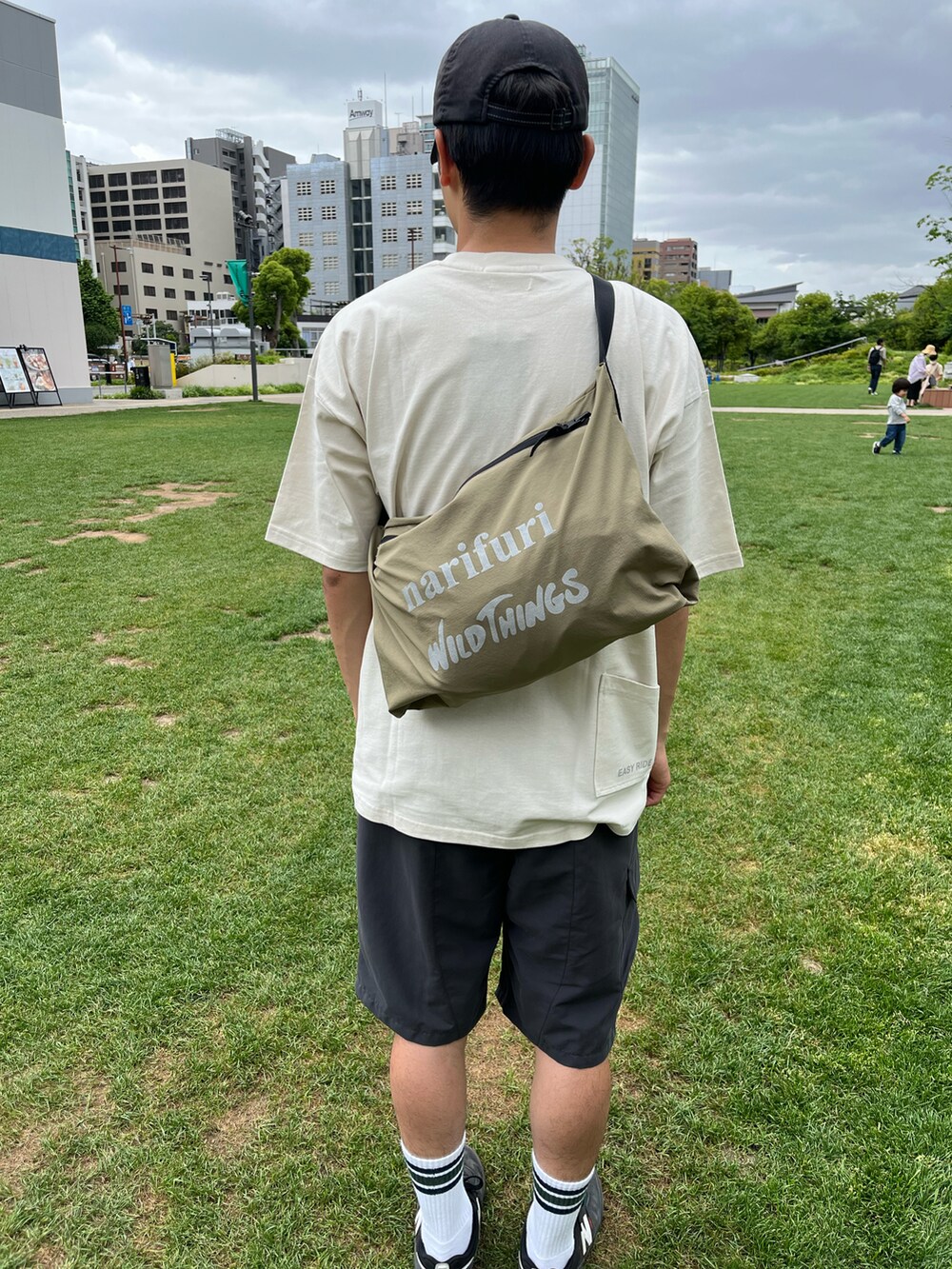 ブラック系のカーゴパンツ、ベージュ系のマウンテンパーカー、ホワイト系のTシャツ/カットソーを着用したメンズの春コーディネートの3枚目の写真