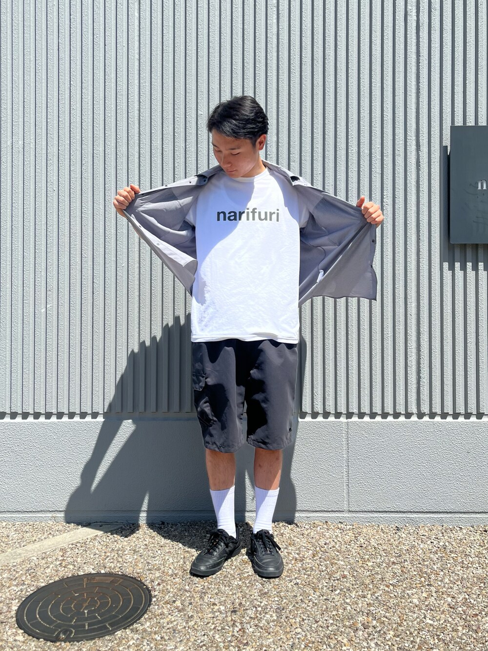 ブラック系のカーゴパンツ、グレー系のシャツ/ブラウス、ホワイト系のTシャツ/カットソーを着用したメンズの春コーディネートの2枚目の写真