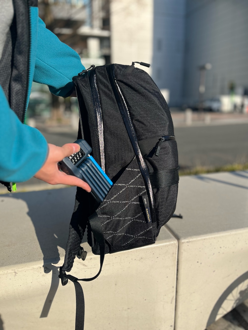 グレー系のパーカー、ブルー系のブルゾン、ブラック系のバックパック/リュックを着用したメンズの春コーディネートの4枚目の写真