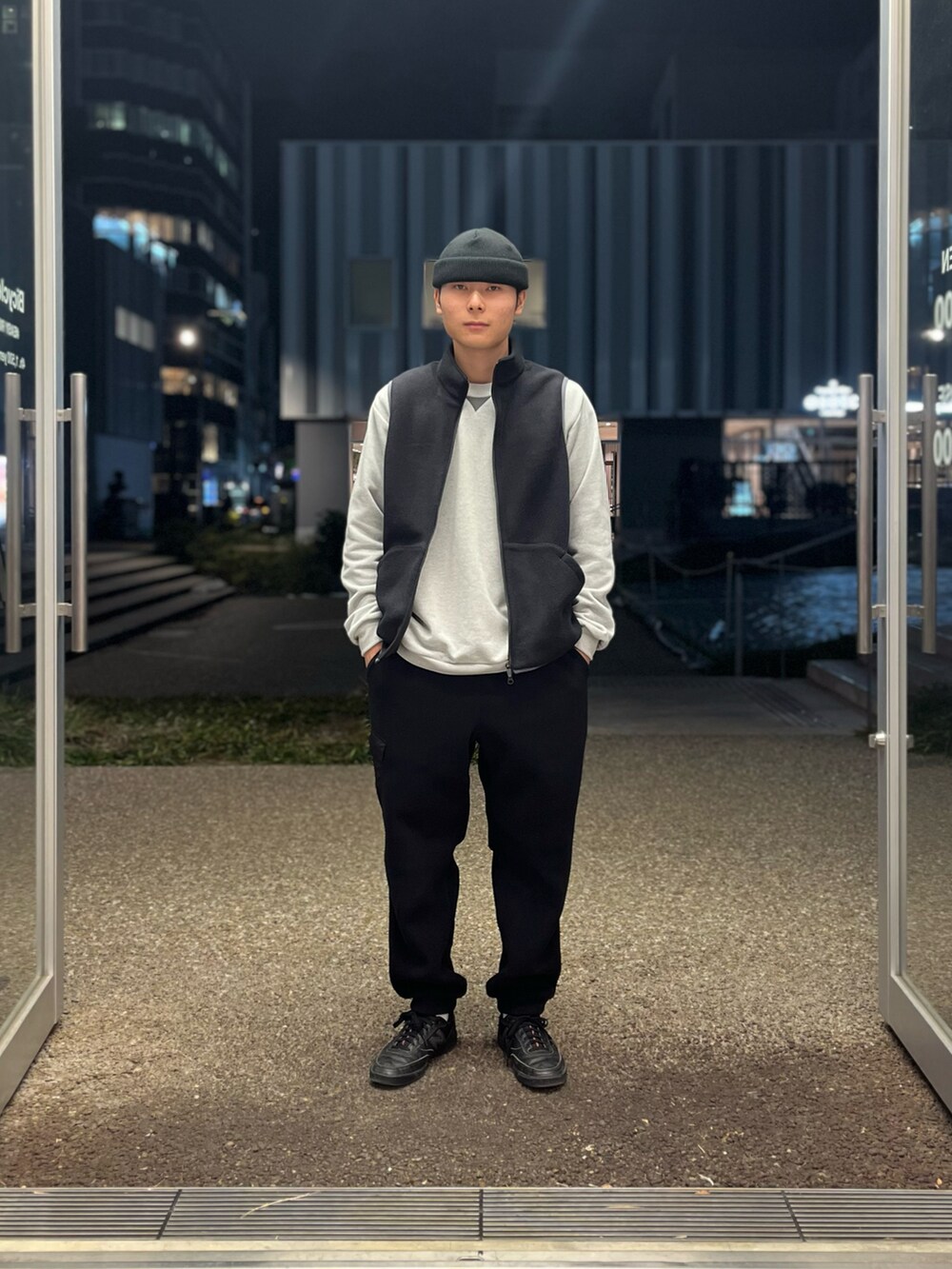 ブラック系のスニーカー、ブラック系のカーゴパンツ、グレー系のスウェットを着用したメンズの冬コーディネートの2枚目の写真