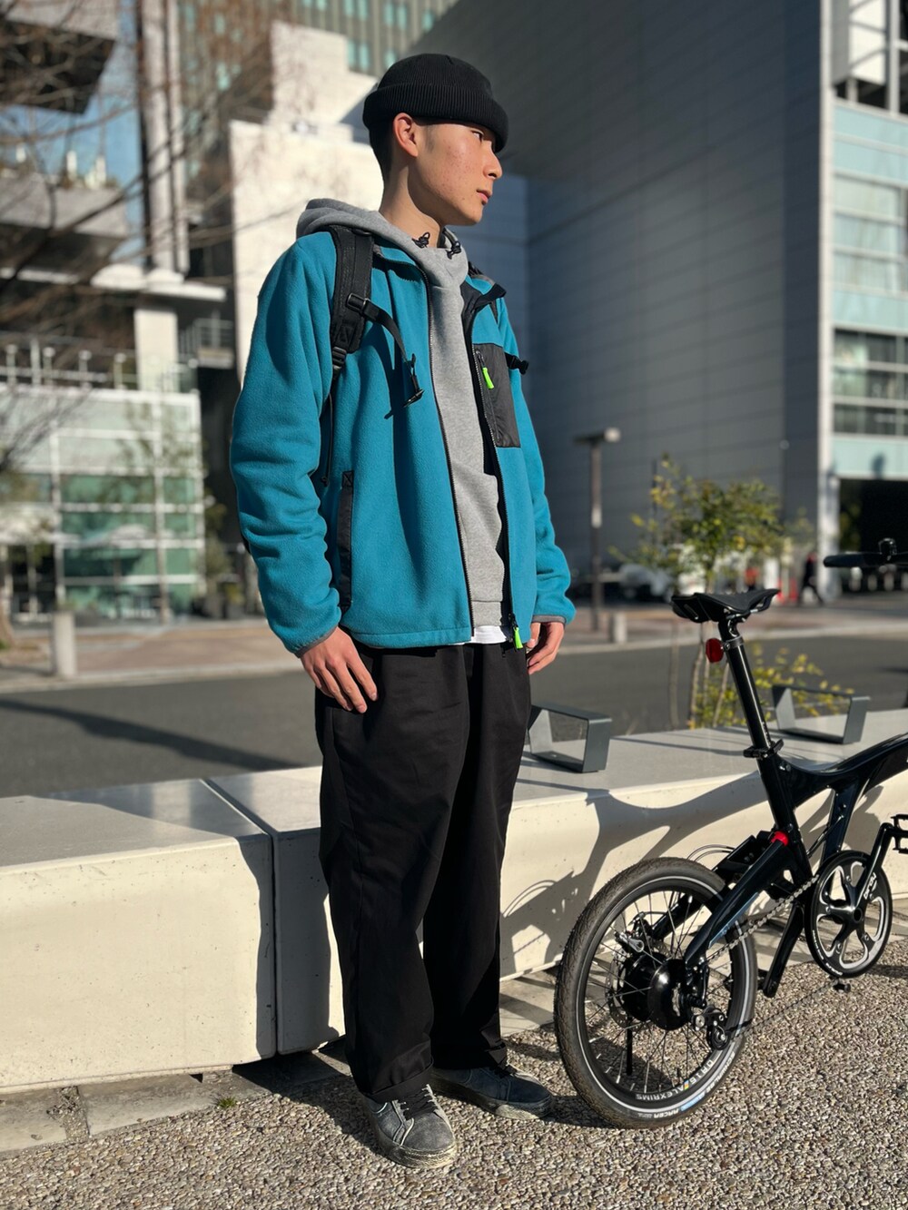 グレー系のパーカー、ブルー系のブルゾン、ブラック系のバックパック/リュックを着用したメンズの春コーディネートの2枚目の写真