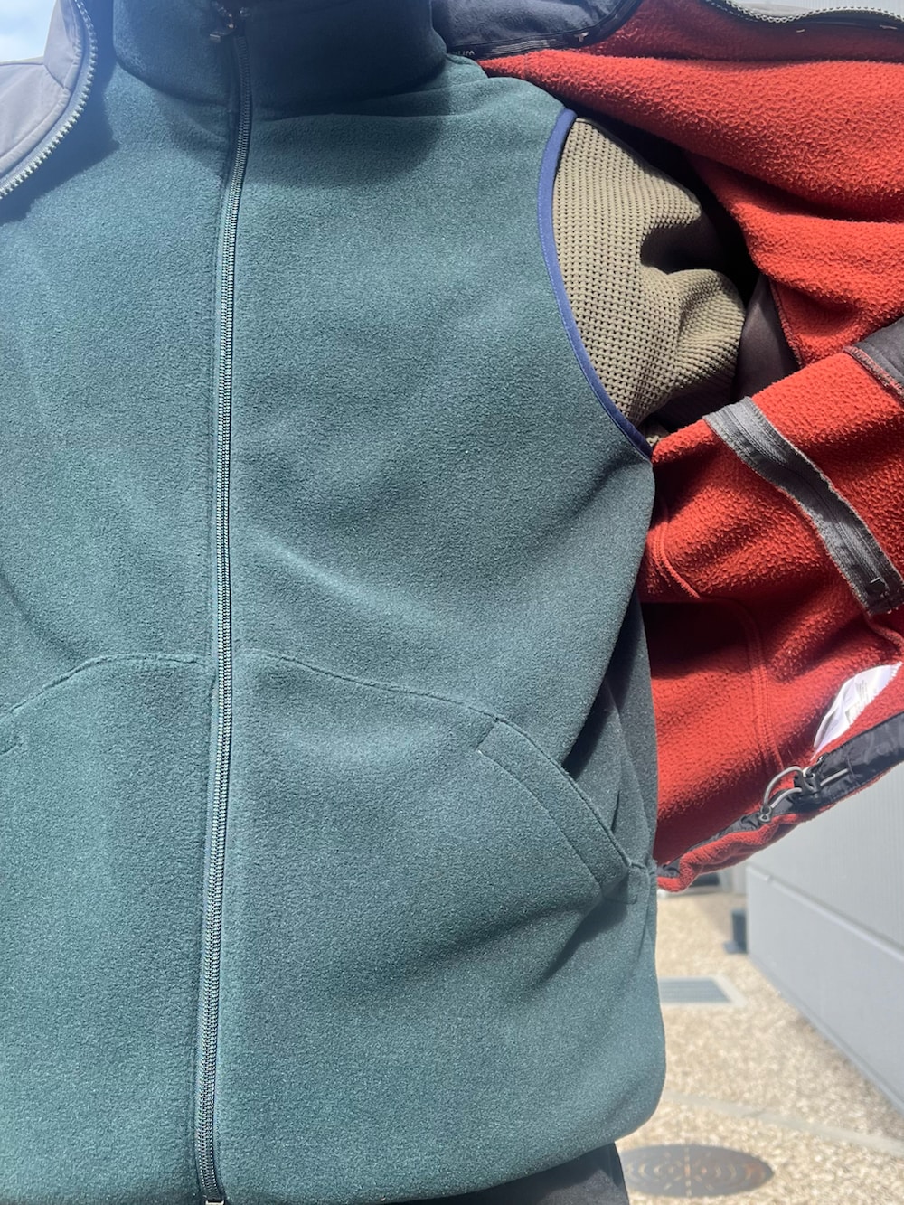 ブラック系のデニムパンツ、ブラック系のスニーカー、グリーン系のベストを着用したメンズの冬コーディネートの2枚目の写真