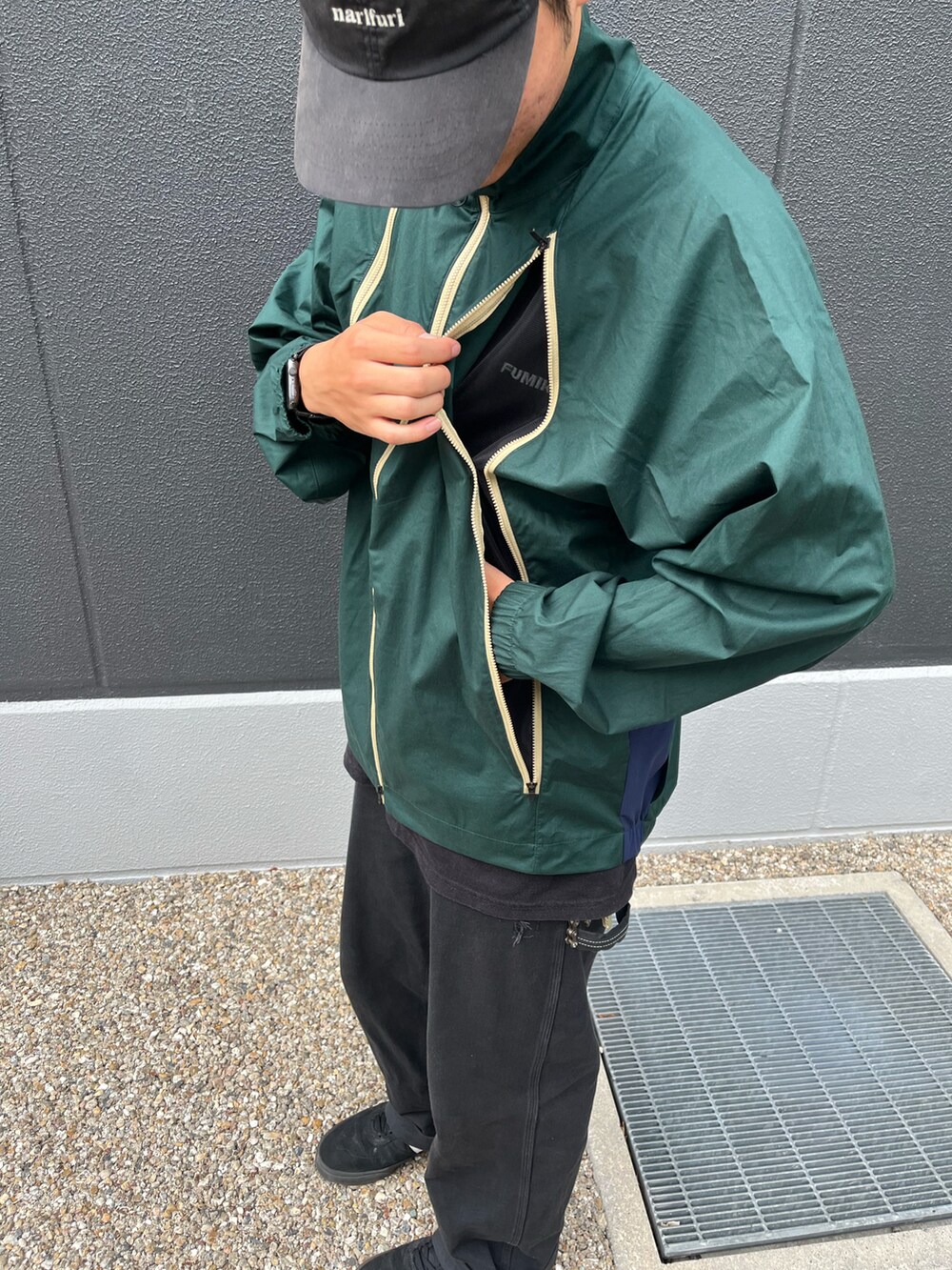 グリーン系のブルゾン、ブラック系のキャップを着用したメンズの秋コーディネートの2枚目の写真