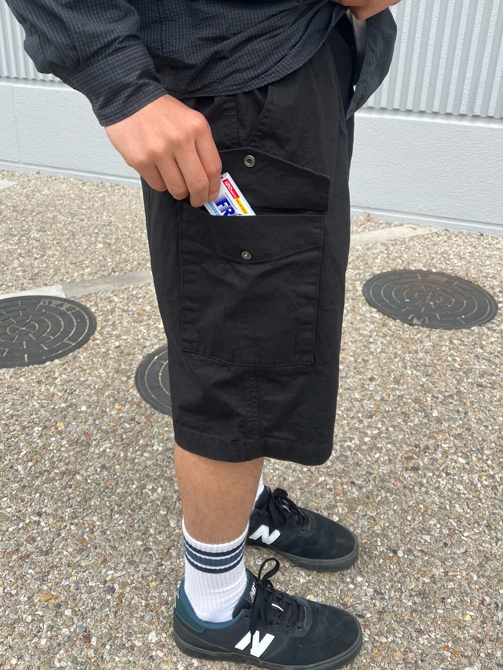 ブラック系のカーゴパンツ、ブルー系のシャツ/ブラウス、ブラック系のキャップを着用したメンズの春コーディネートの2枚目の写真