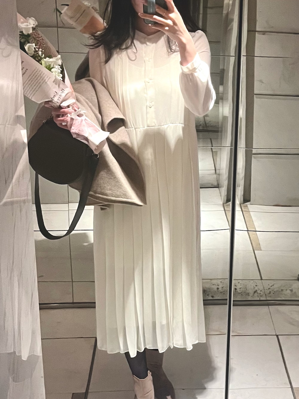 ホワイト系のシャツワンピース、ベージュ系のブーツ、ベージュ系のポンチョを着用したレディースの秋コーディネートの3枚目の写真