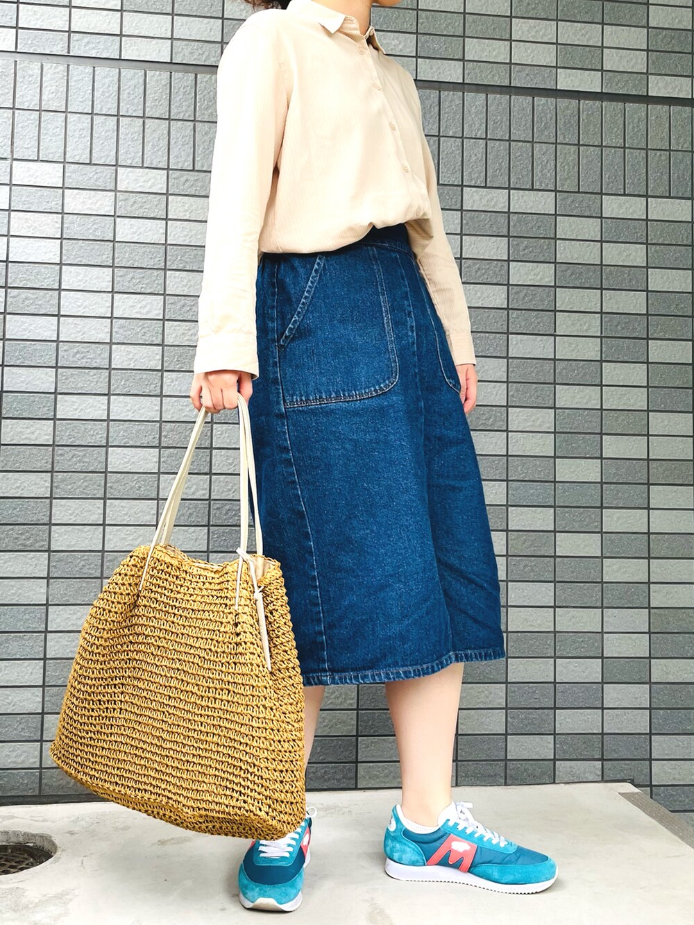ベージュ系のシャツ/ブラウス、ブラウン系のトートバッグ、ブルー系のデニムスカートを着用したレディースの夏コーディネートの2枚目の写真