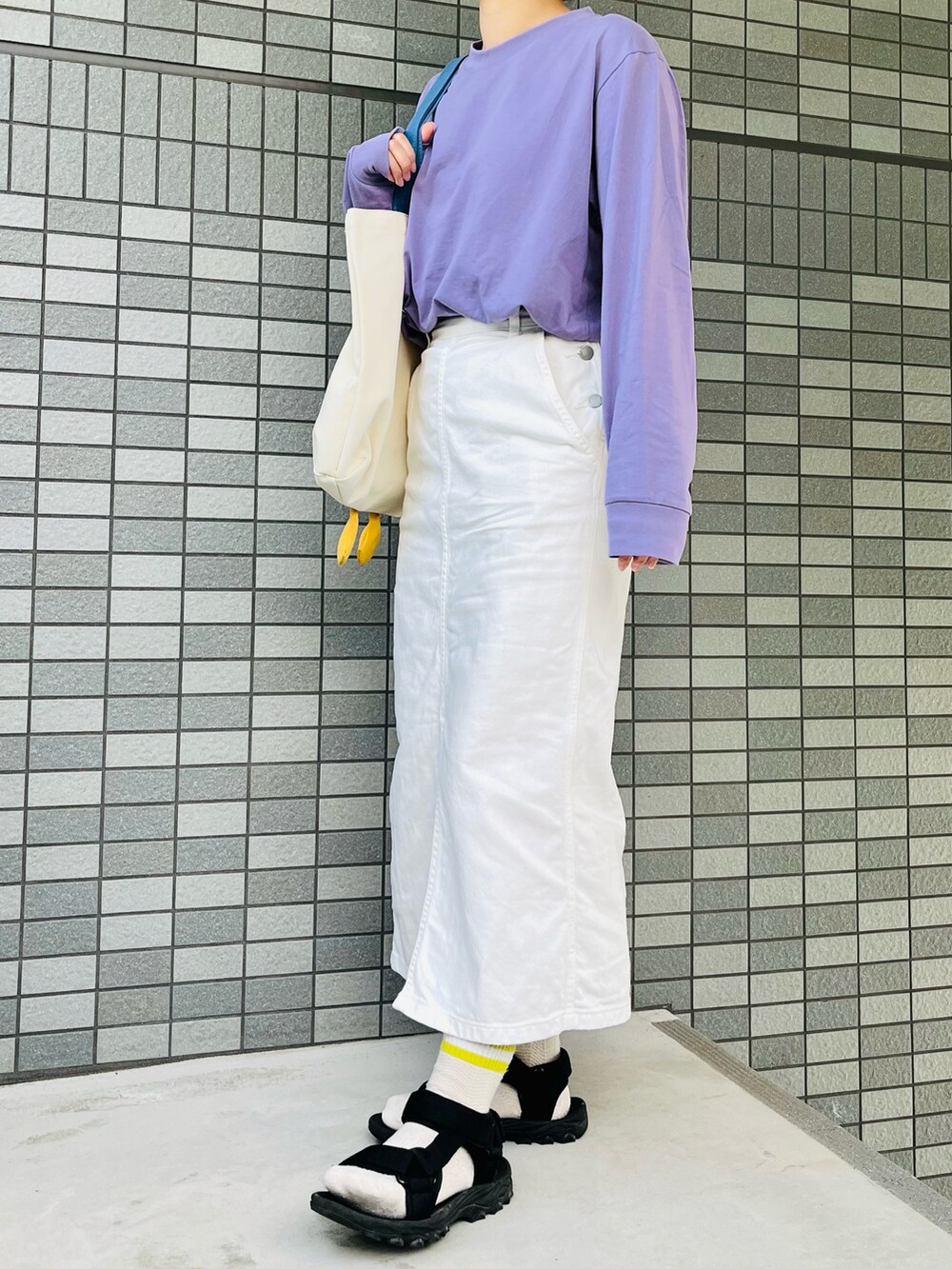 パープル系のTシャツ/カットソー、ホワイト系のデニムスカート、ホワイト系のトートバッグを着用したレディースの夏コーディネートの2枚目の写真