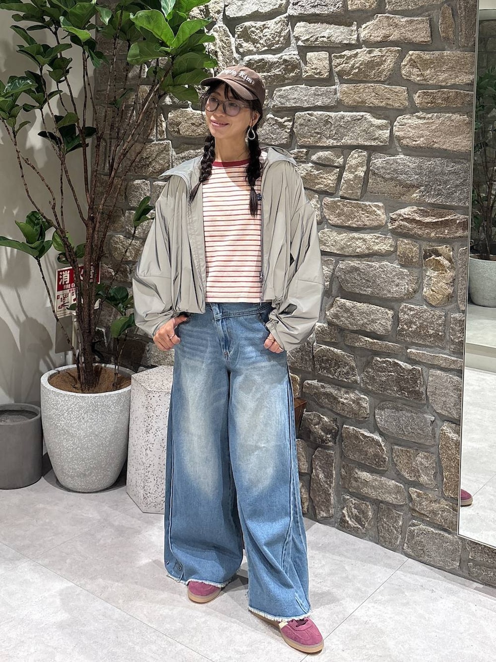 ブルー系のデニムパンツ、ピンク系のTシャツ/カットソー、ブラウン系のスニーカーを着用したレディースの秋コーディネートの3枚目の写真
