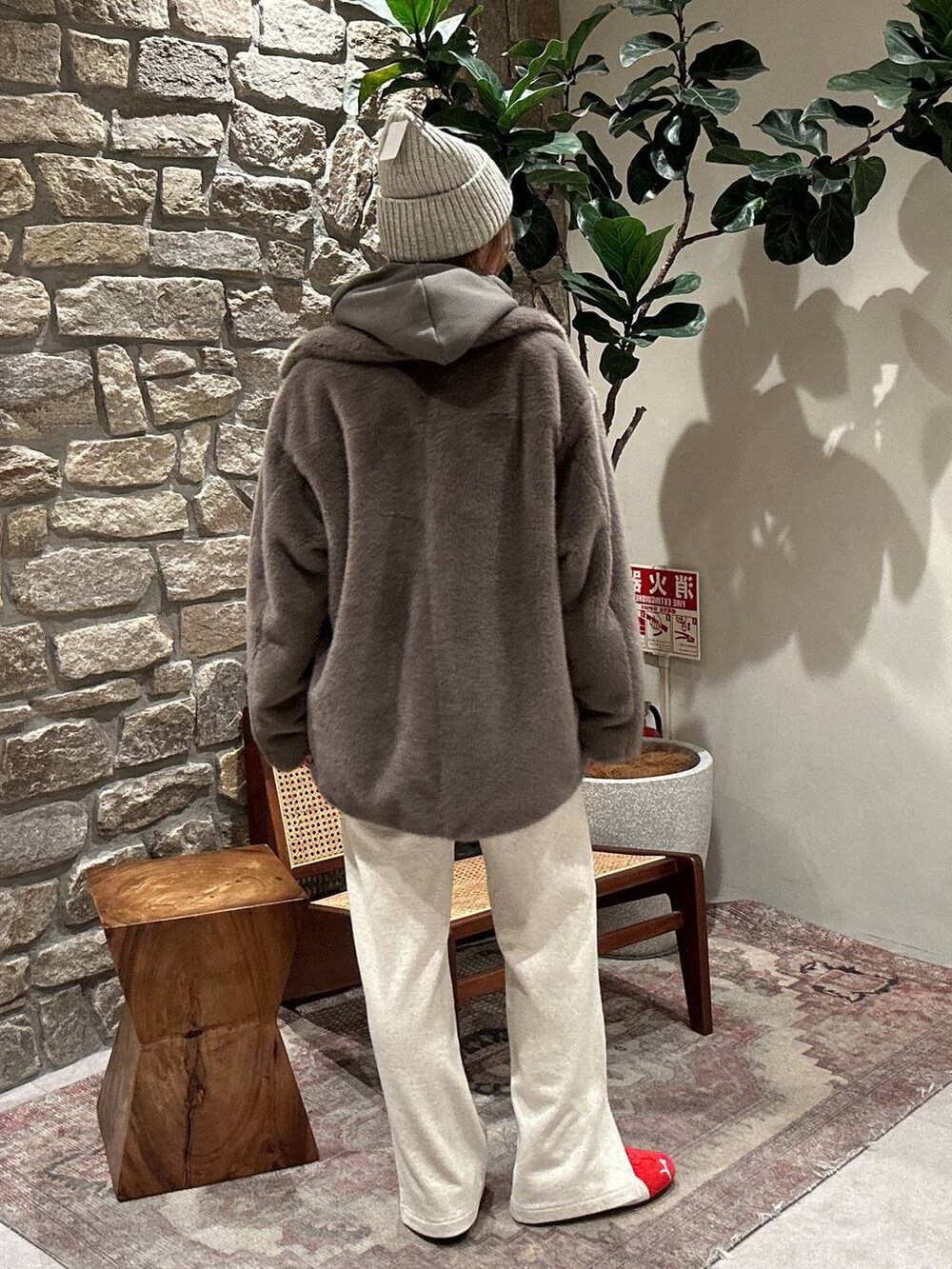 グレー系のパーカー、ベージュ系のブルゾン、ホワイト系のスウェットパンツを着用したレディースの秋コーディネートの2枚目の写真