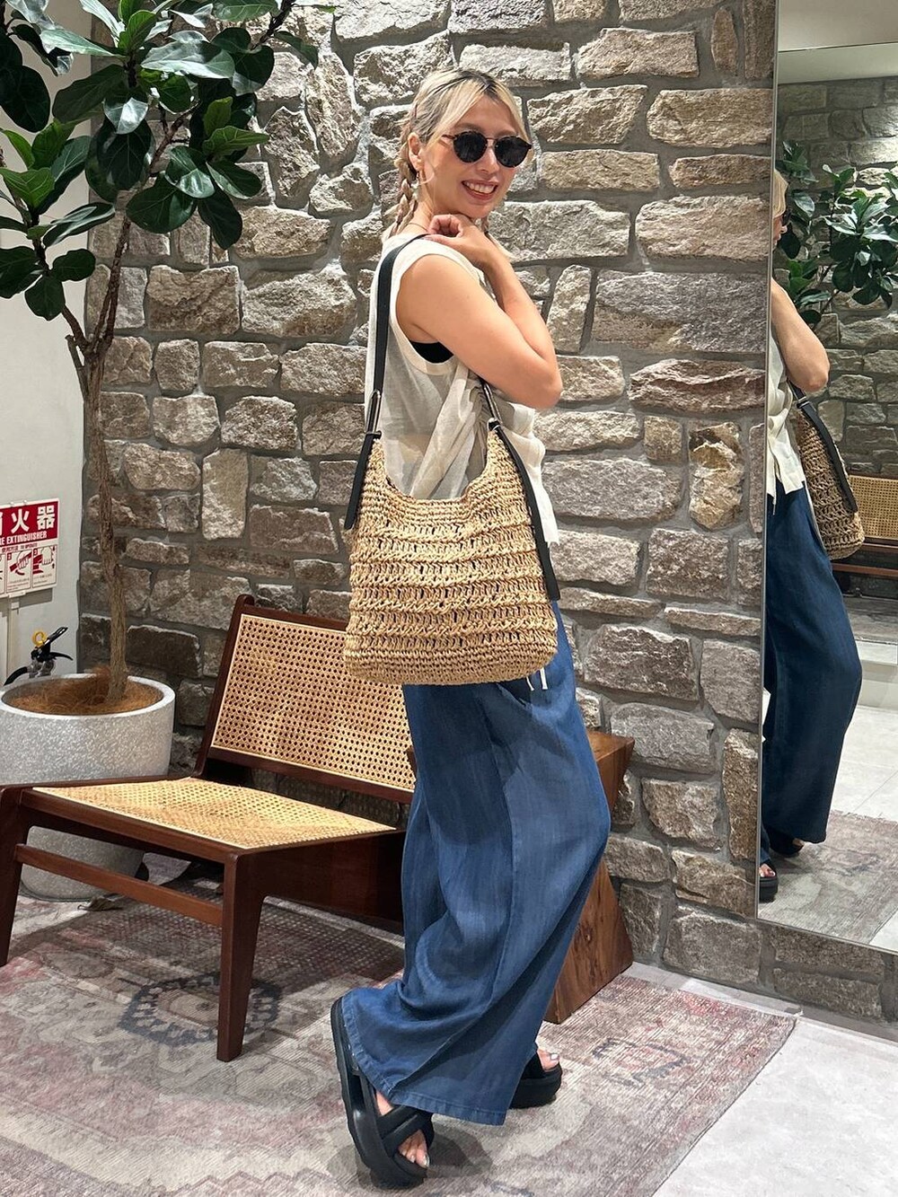 ブルー系のその他パンツ、ホワイト系のニット/セーター、ブラウン系のサングラスを着用したレディースの夏コーディネートの2枚目の写真