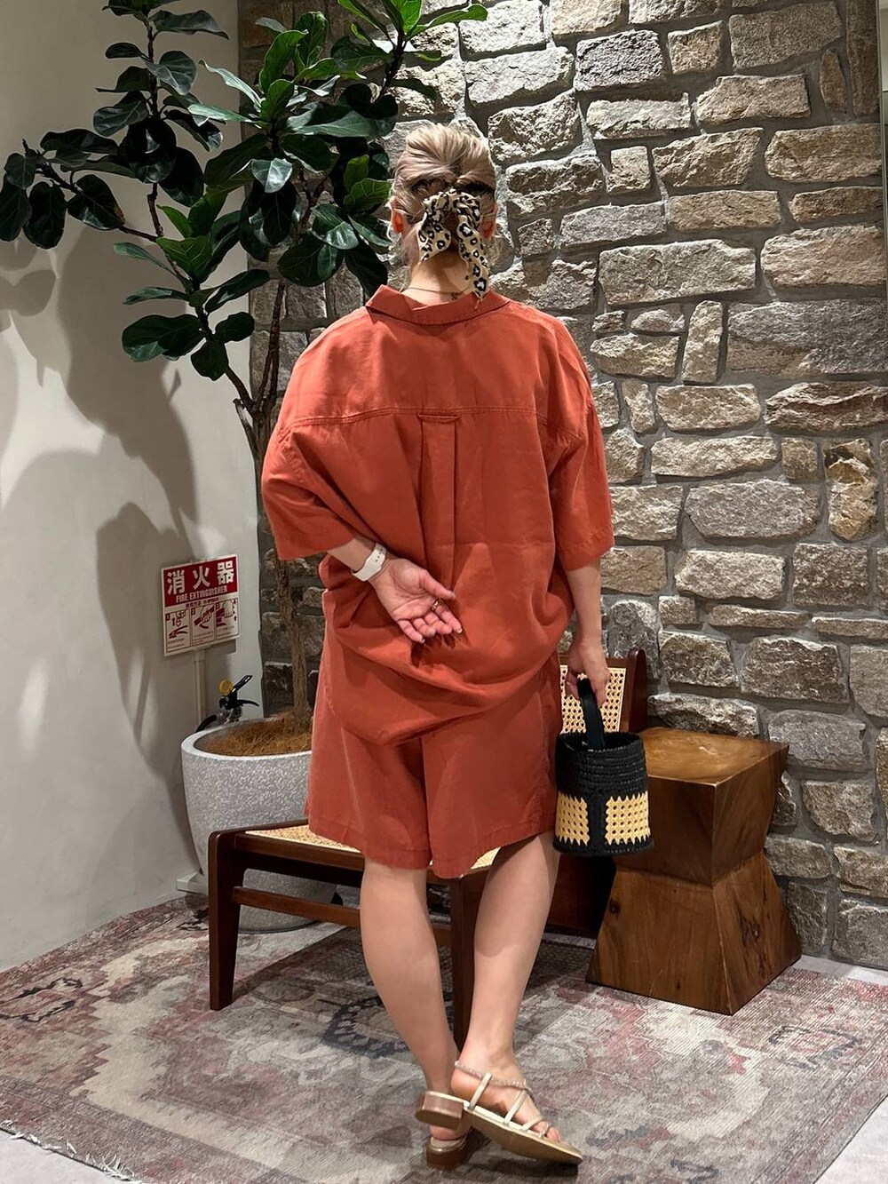 オレンジ系のシャツ/ブラウス、ブラウン系のその他パンツ、ブラック系のショルダーバッグを着用したレディースの夏コーディネートの3枚目の写真