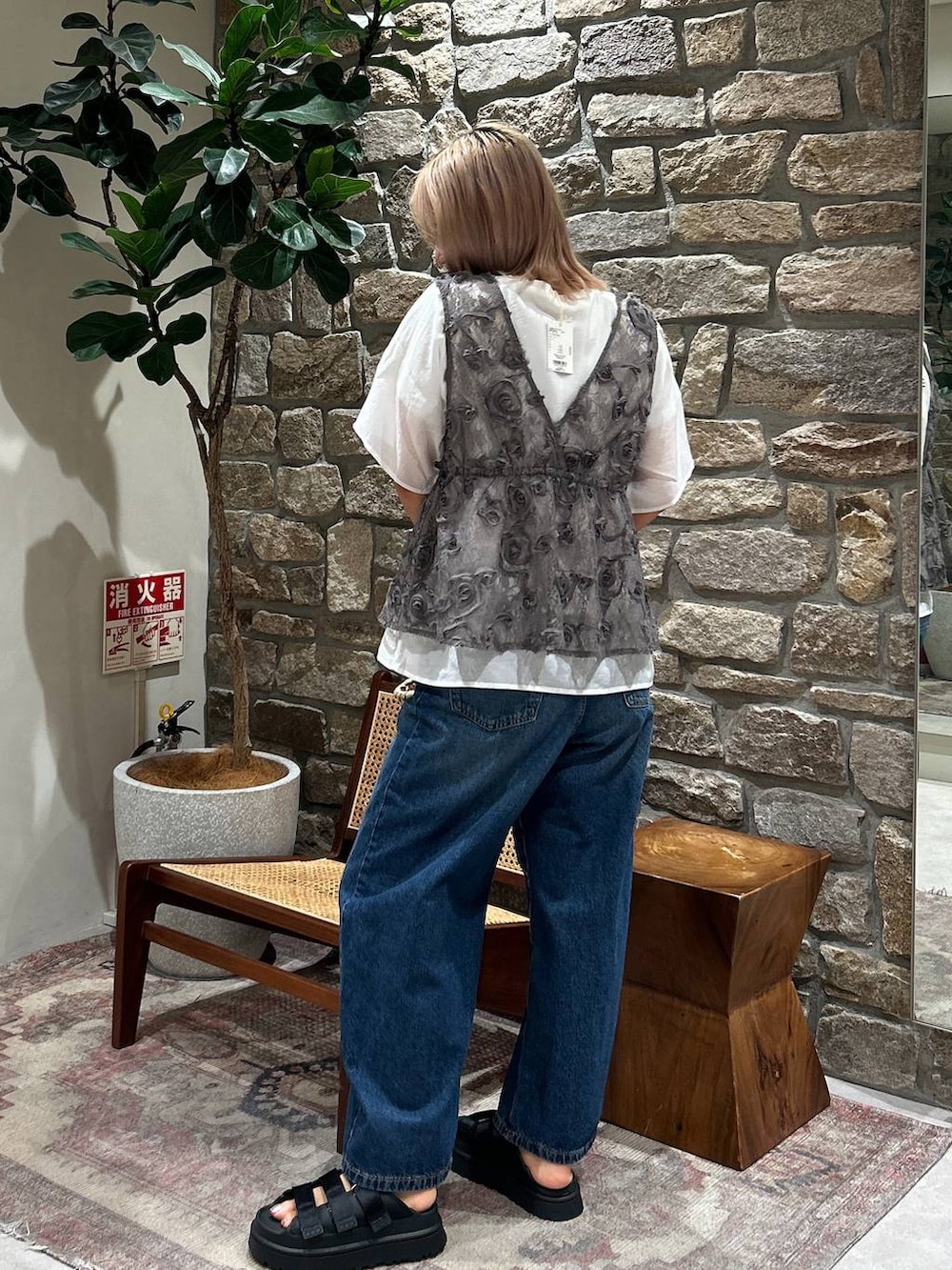 ブラック系のサンダル、ホワイト系のかごバッグ、ブルー系のデニムパンツを着用したレディースの夏コーディネートの3枚目の写真