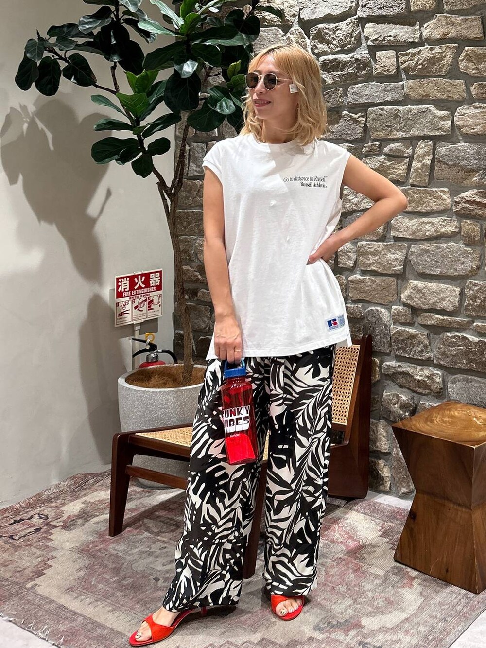 ホワイト系のTシャツ/カットソー、ベージュ系のその他パンツ、レッド系のサンダルを着用したレディースの春コーディネートの2枚目の写真