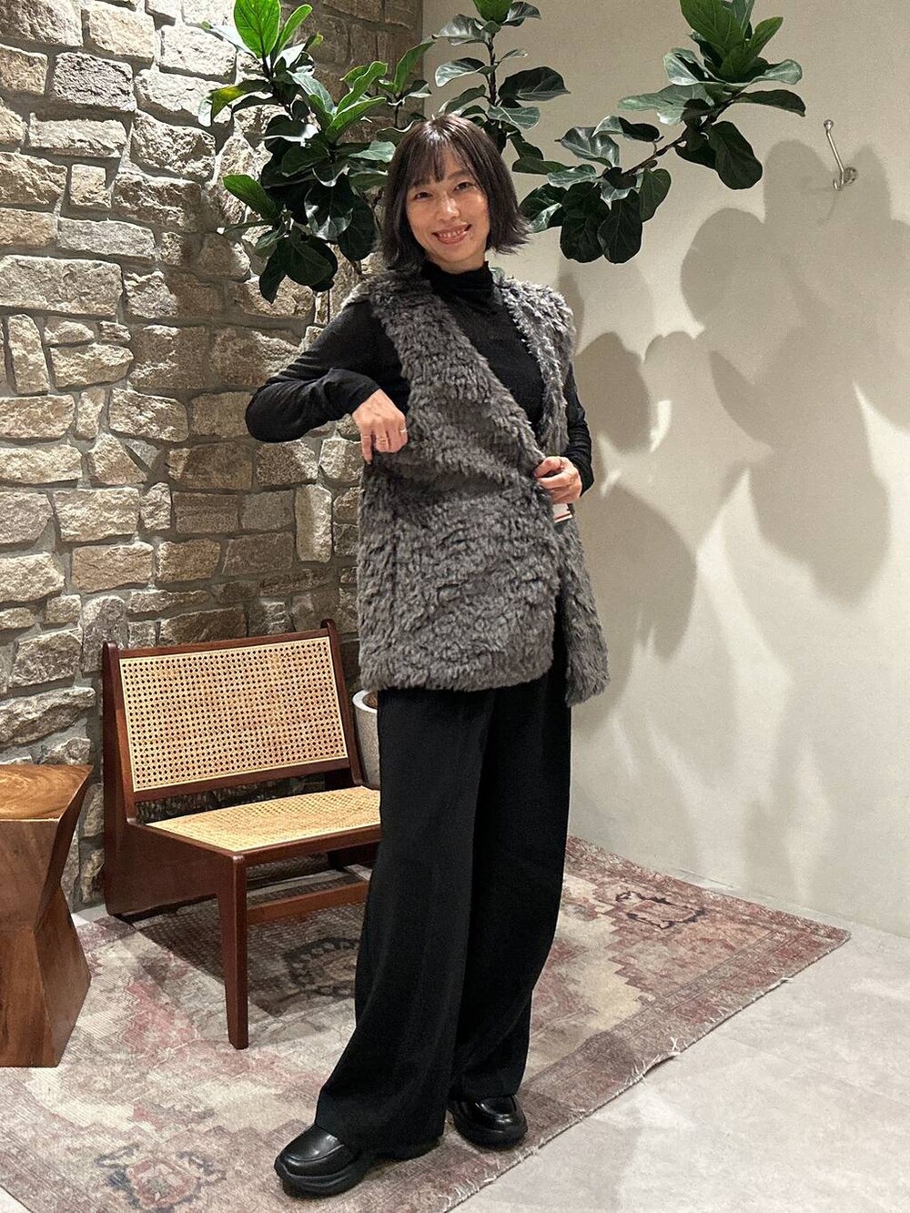 グレー系のベスト、ブラック系のTシャツ/カットソー、ブラック系のその他パンツを着用したレディースの秋コーディネートの2枚目の写真