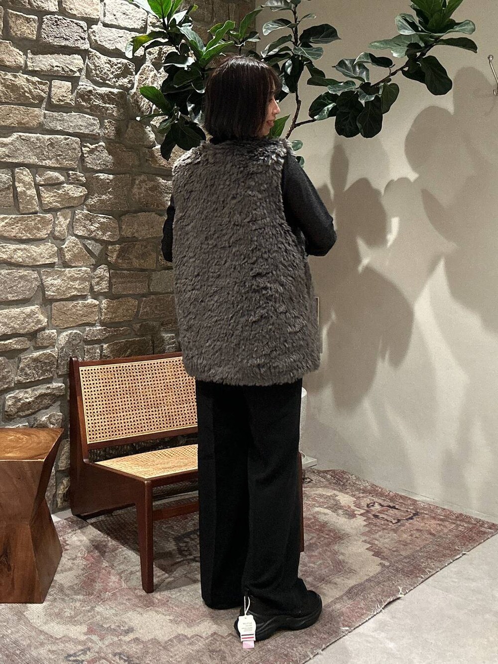 グレー系のベスト、ブラック系のTシャツ/カットソー、ブラック系のその他パンツを着用したレディースの秋コーディネートの3枚目の写真