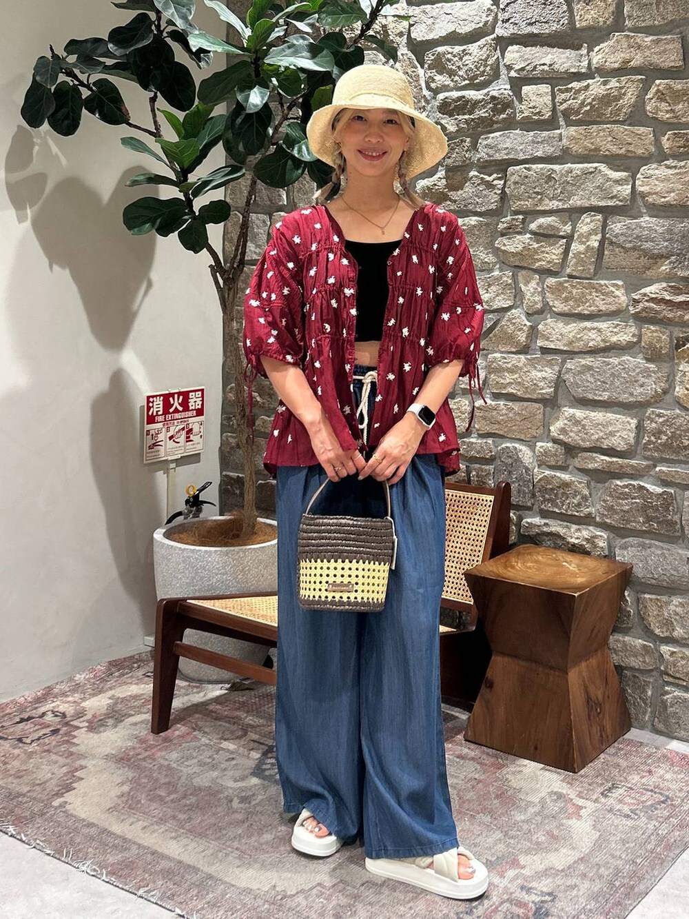 ブラウン系のショルダーバッグ、ブルー系のその他パンツ、レッド系のシャツ/ブラウスを着用したレディースの夏コーディネートの4枚目の写真