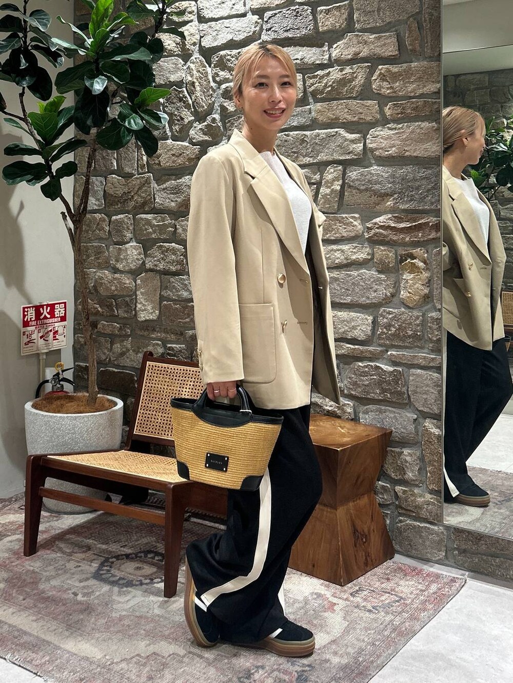 ベージュ系のテーラードジャケット、ブラック系のショルダーバッグ、グレー系のニット/セーターを着用したレディースの春コーディネートの2枚目の写真