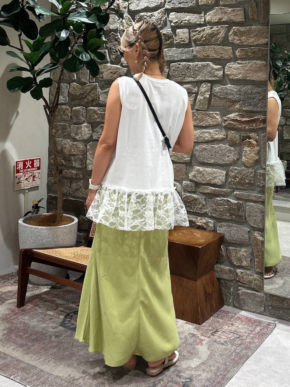 ブラック系のかごバッグ、ホワイト系のサンダル、ホワイト系のTシャツ/カットソーを着用したレディースの夏コーディネートの3枚目の写真